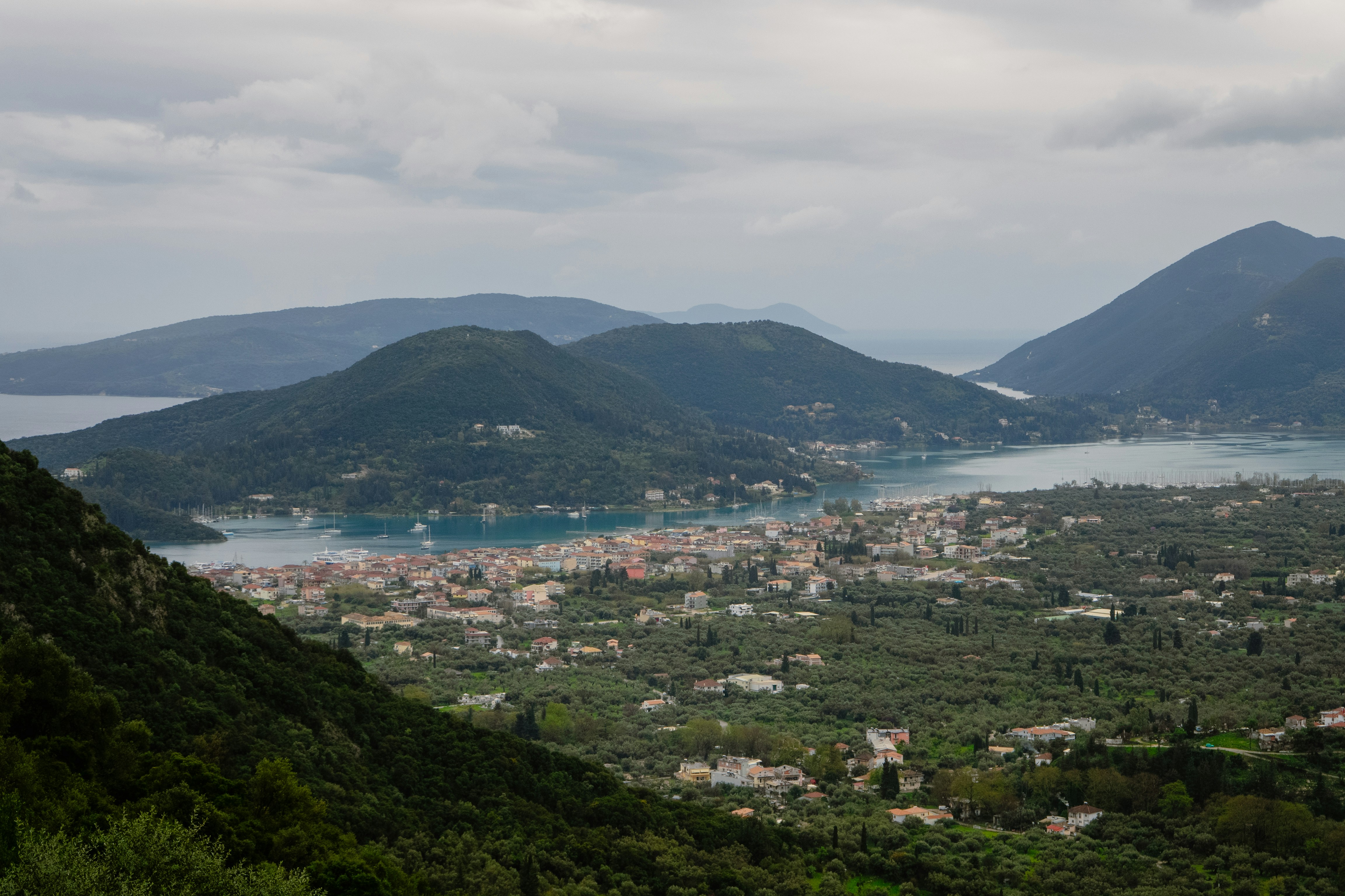 Ville côtière nichée entre des collines verdoyantes et des eaux bleues.
