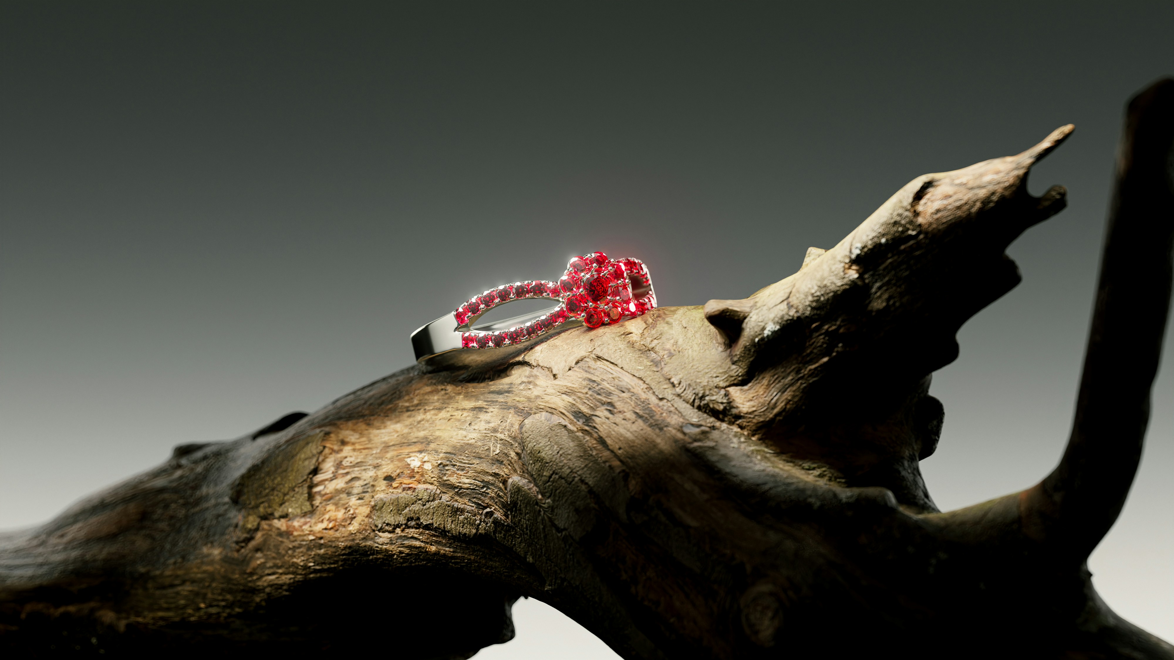 A red gemstone ring rests on weathered wood