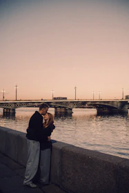 Couple embracing by the water at sunset