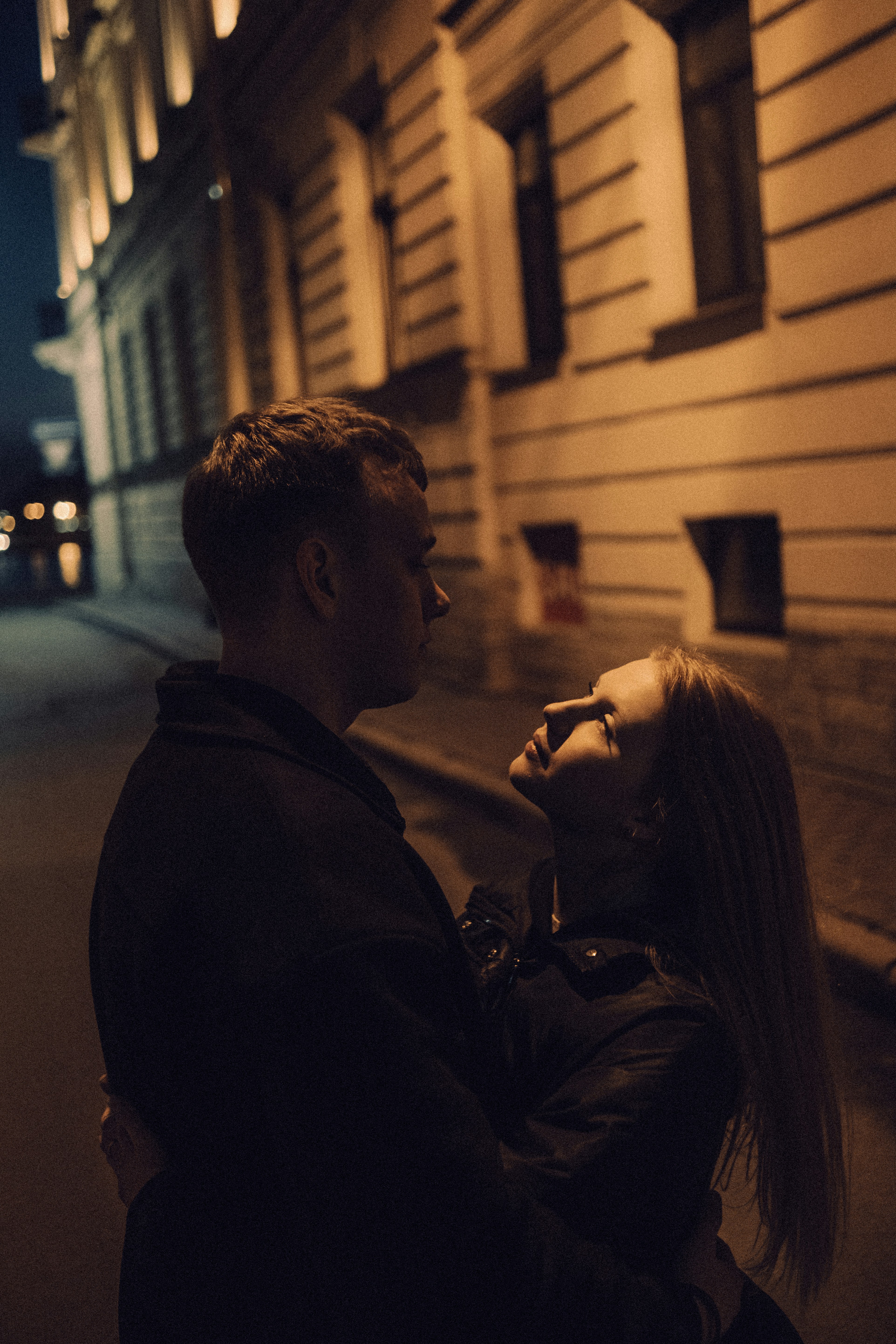 薄暗い街の通りで抱き合うカップル