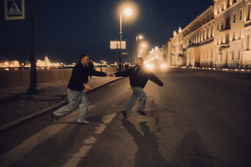 two men running across a city street at night