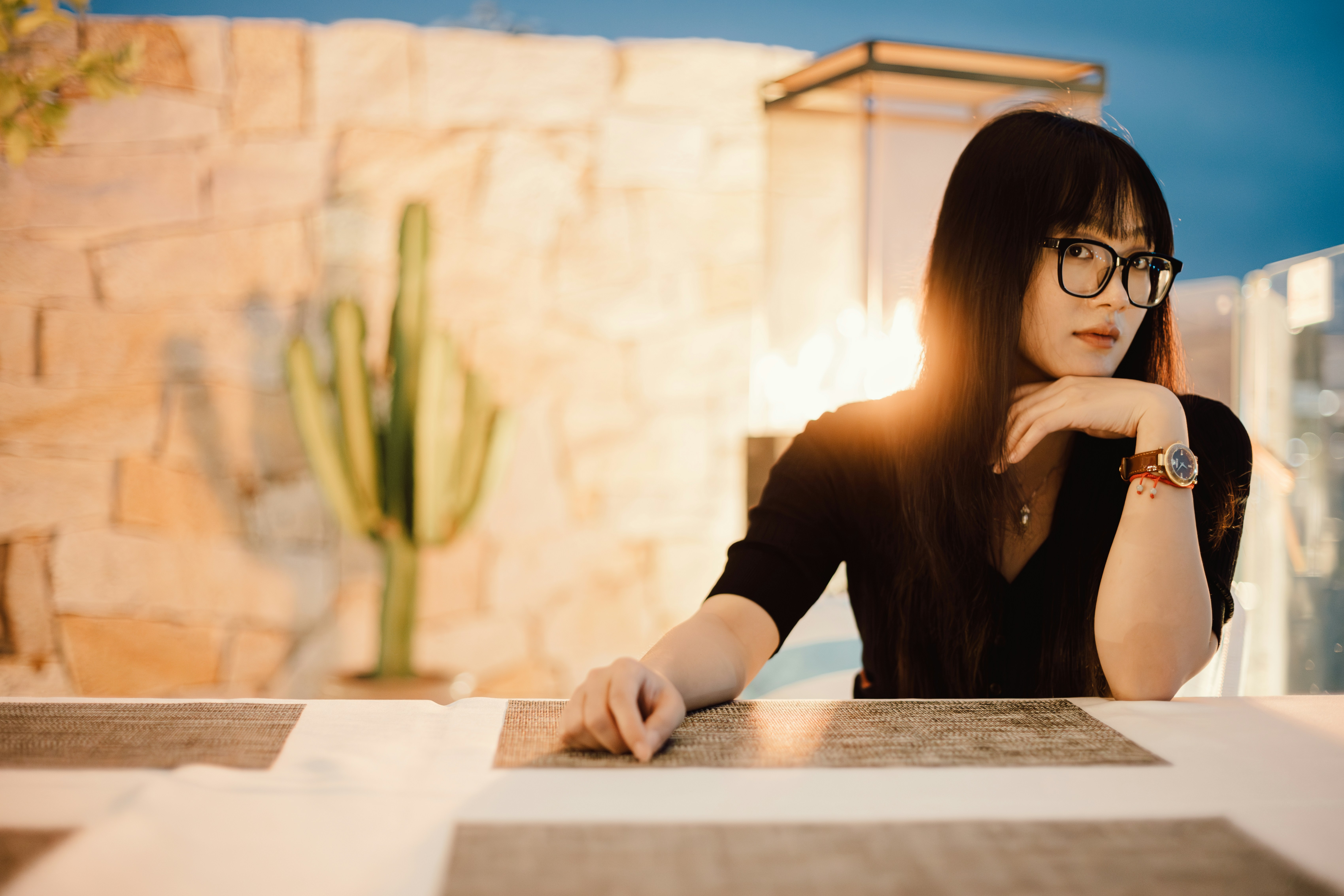 Young adult sitting at a table reflecting on her patterns