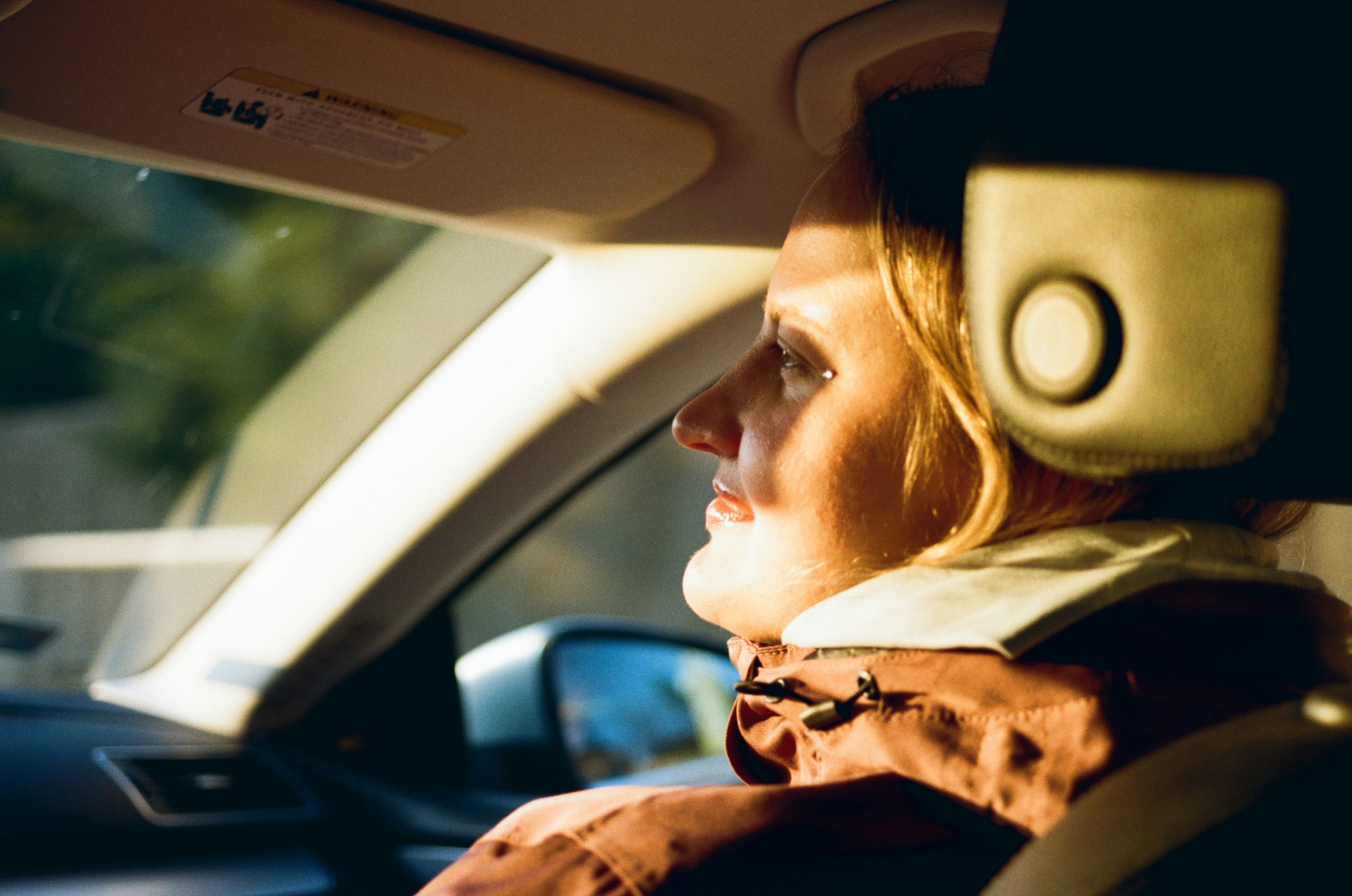 Woman driving car with sun shining through window
