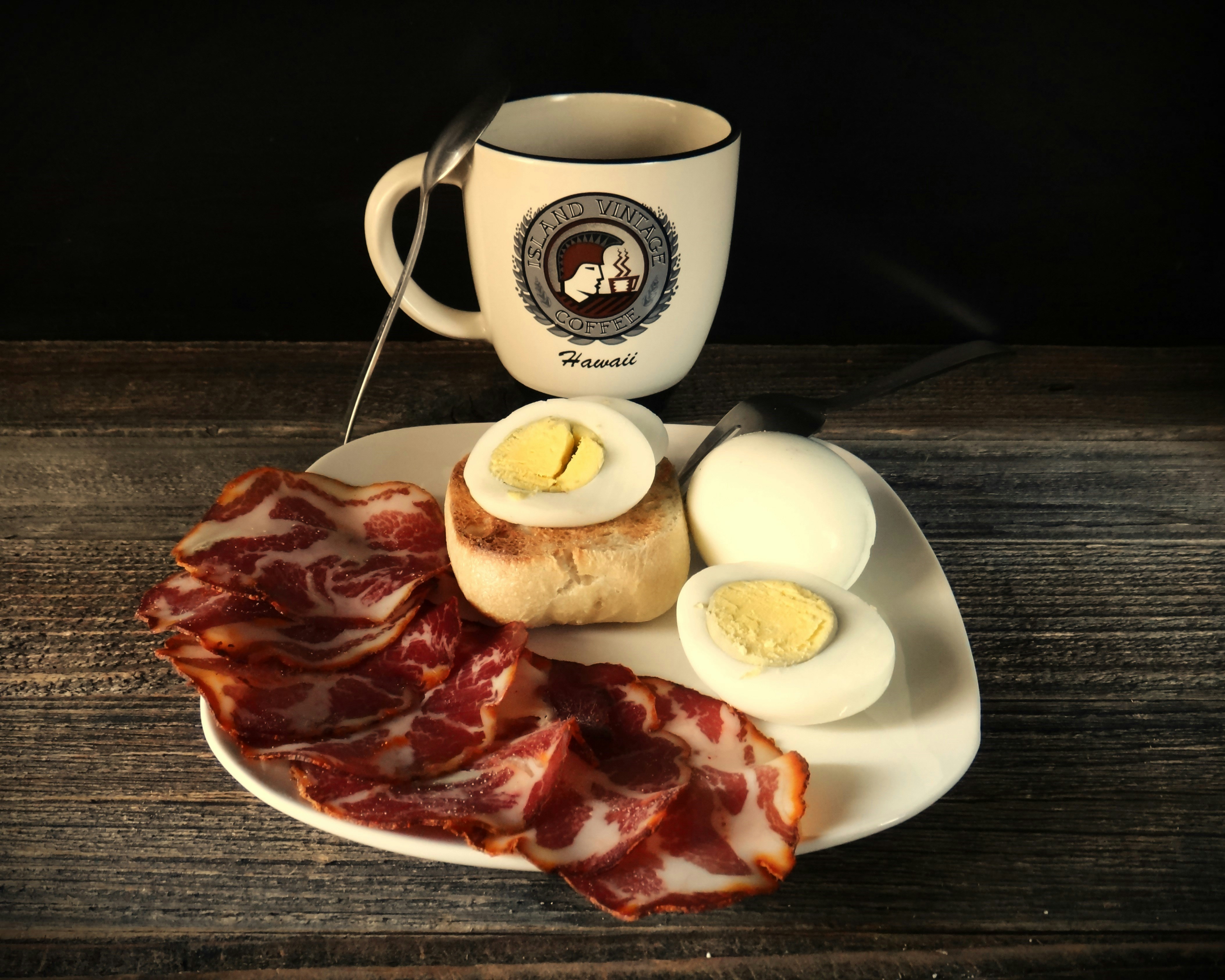 A breakfast plate with bread, eggs and coffee in soft morning light