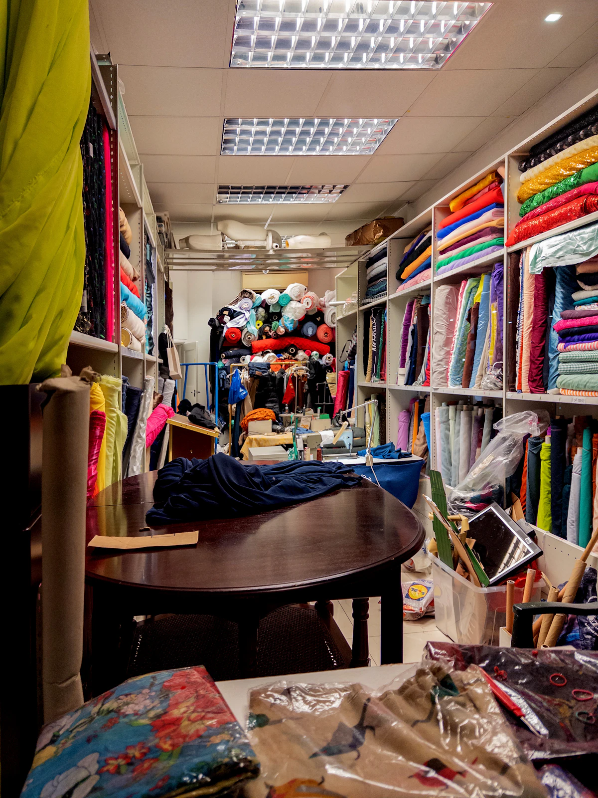 Étagères d'une boutique remplies de rouleaux de tissus colorés