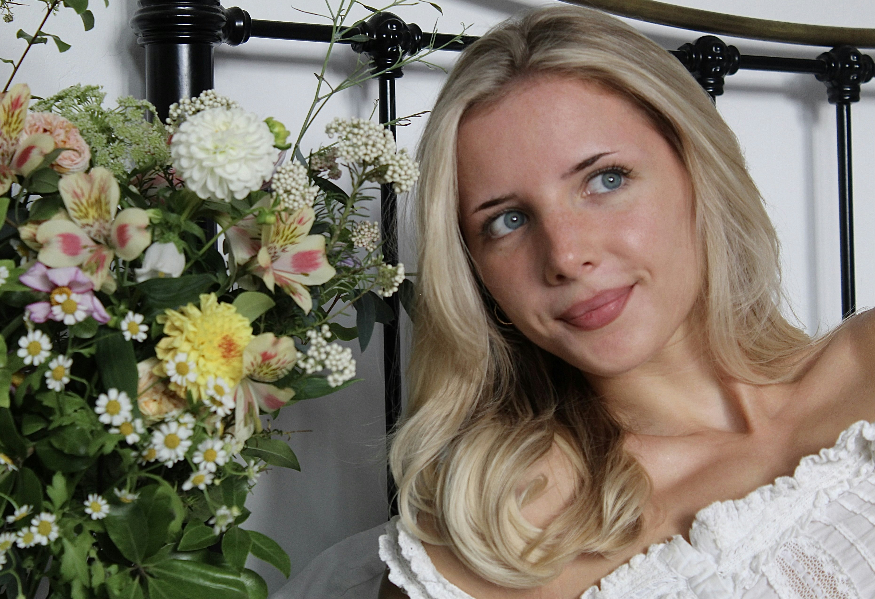 Blonde woman with flowers in bed