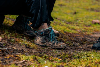 Muddy hiking boots resting on wet ground