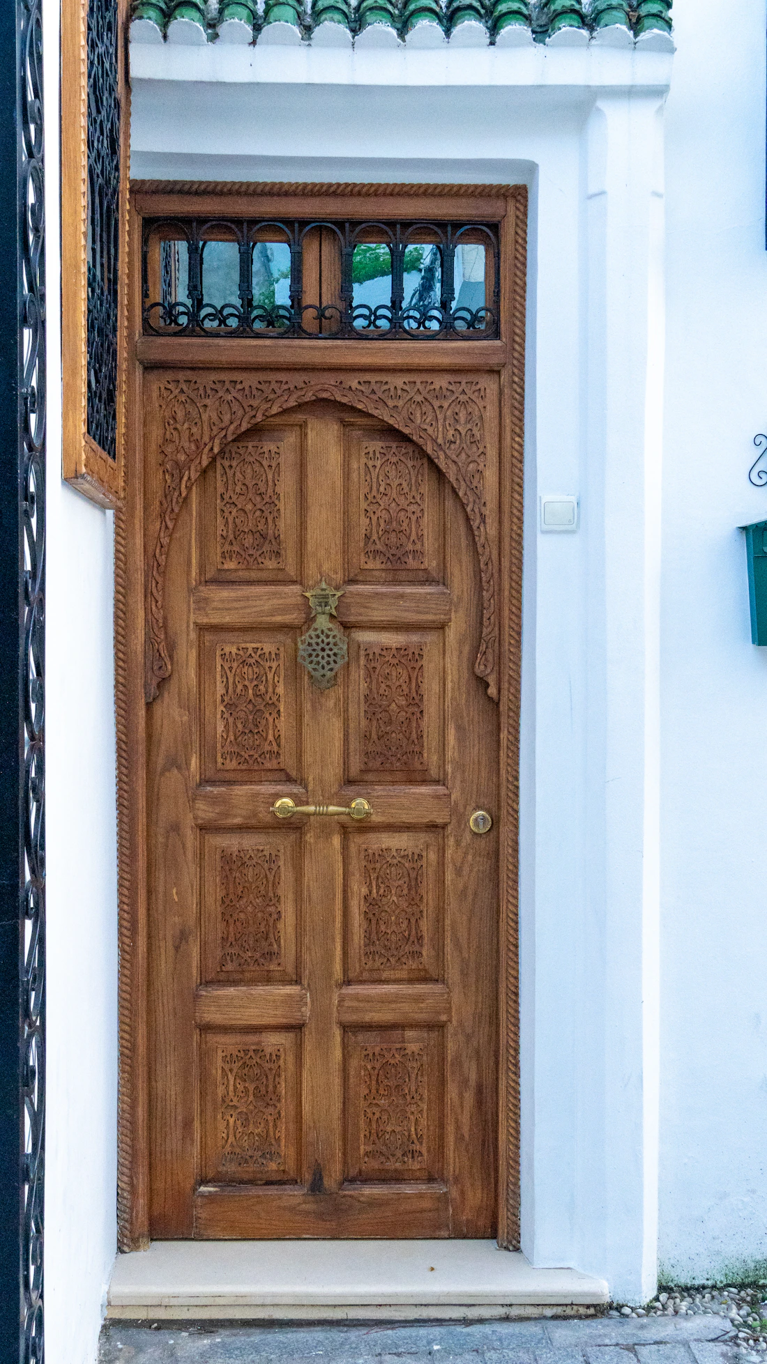 Porte en bois sculpté avec ferrures en laiton, détail traditionnel marocain.