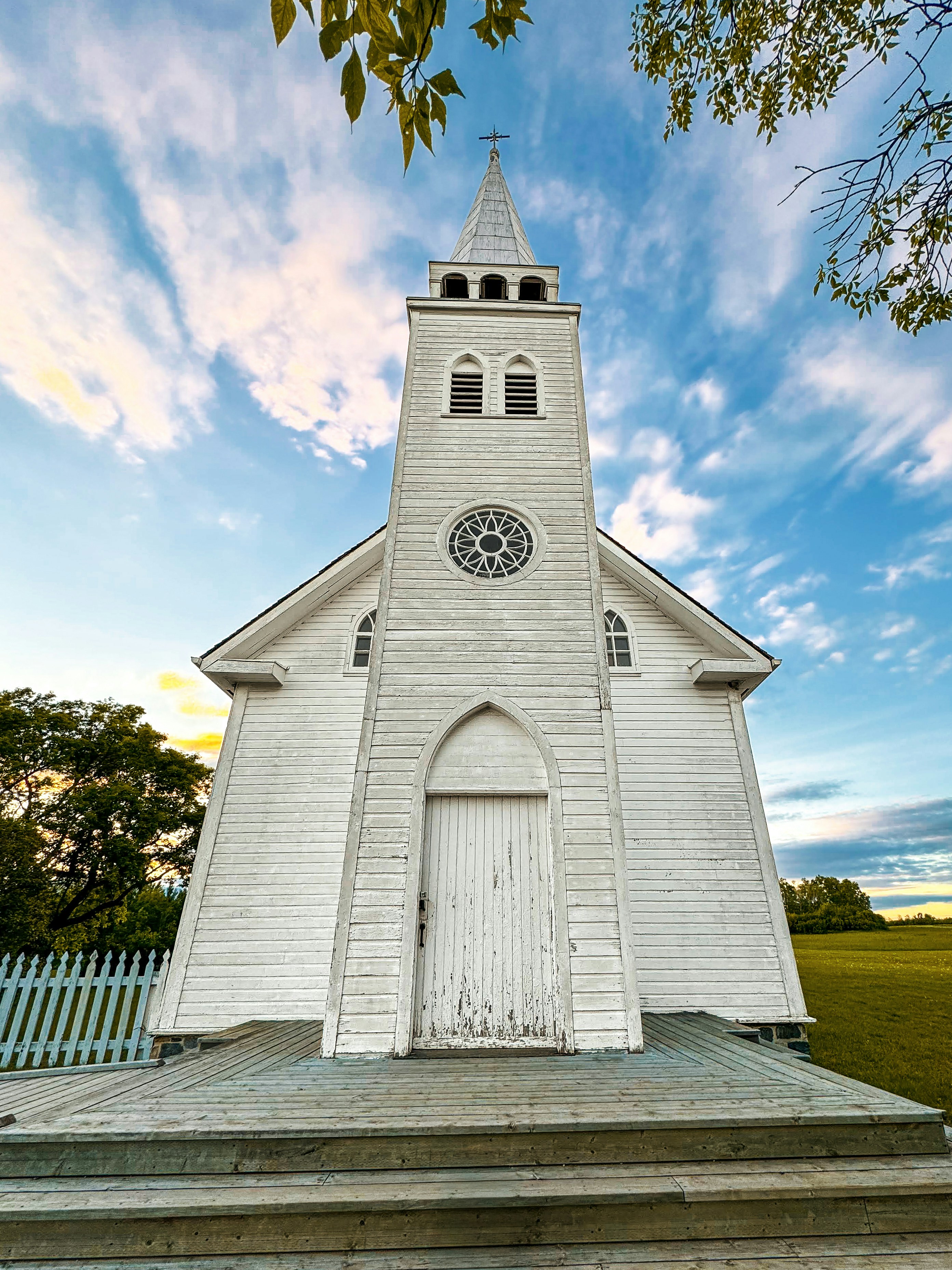 Weiße Holzkirche mit Turm unter bewölktem Himmel