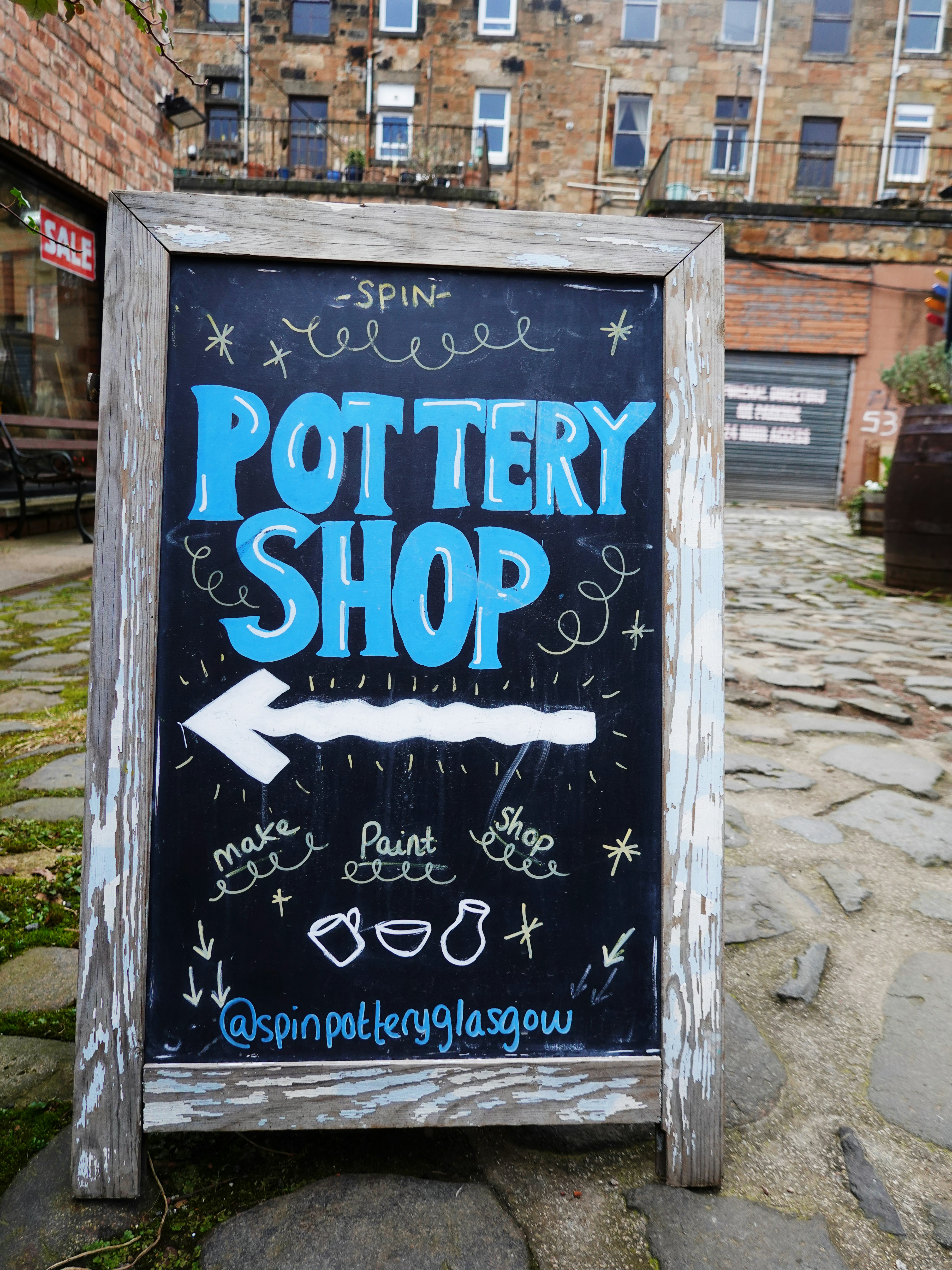 Chalkboard sign for pottery shop with arrow.