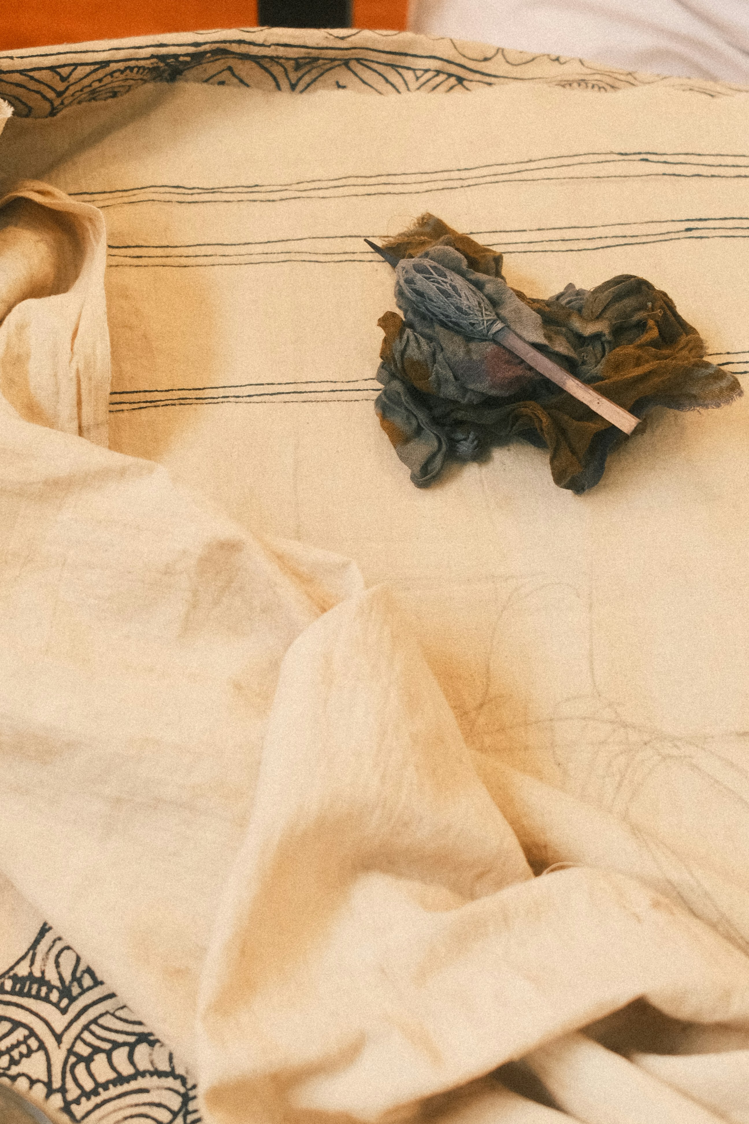 Bundled fabric scraps and a wooden stick on cloth