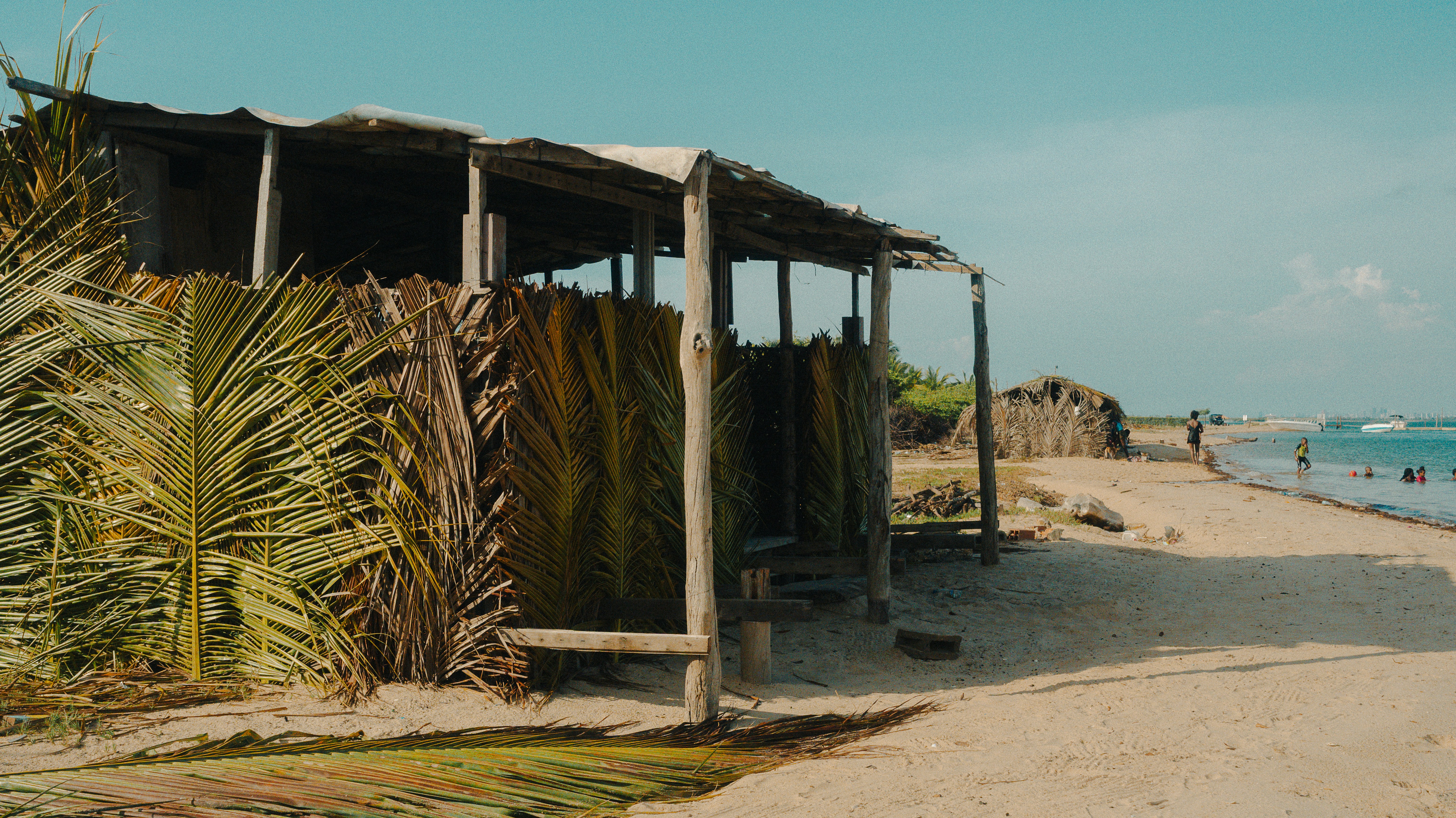 Rustic beach hut made of palm leaves and wood.