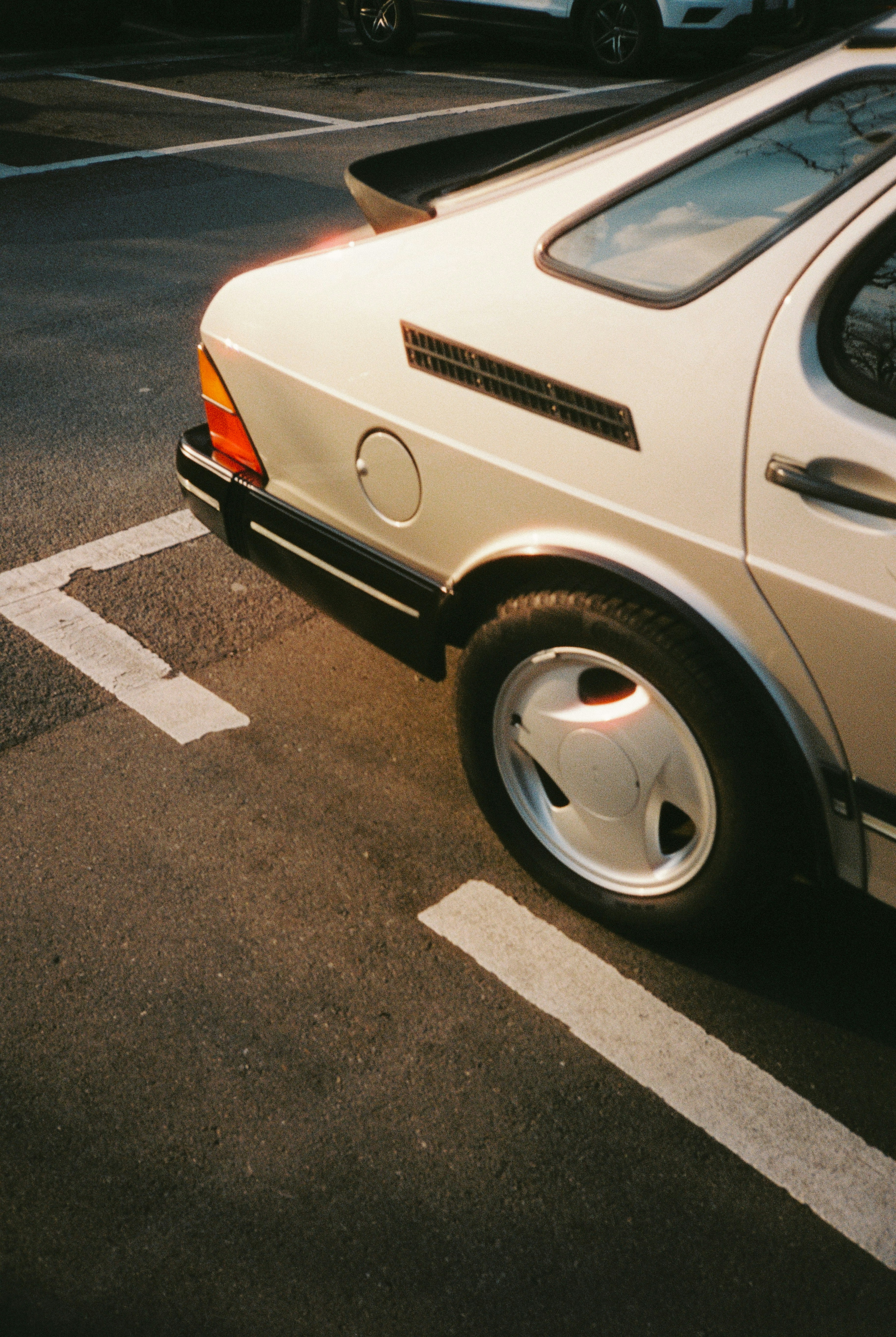 Ein weißer Oldtimer, der auf Asphalt geparkt ist