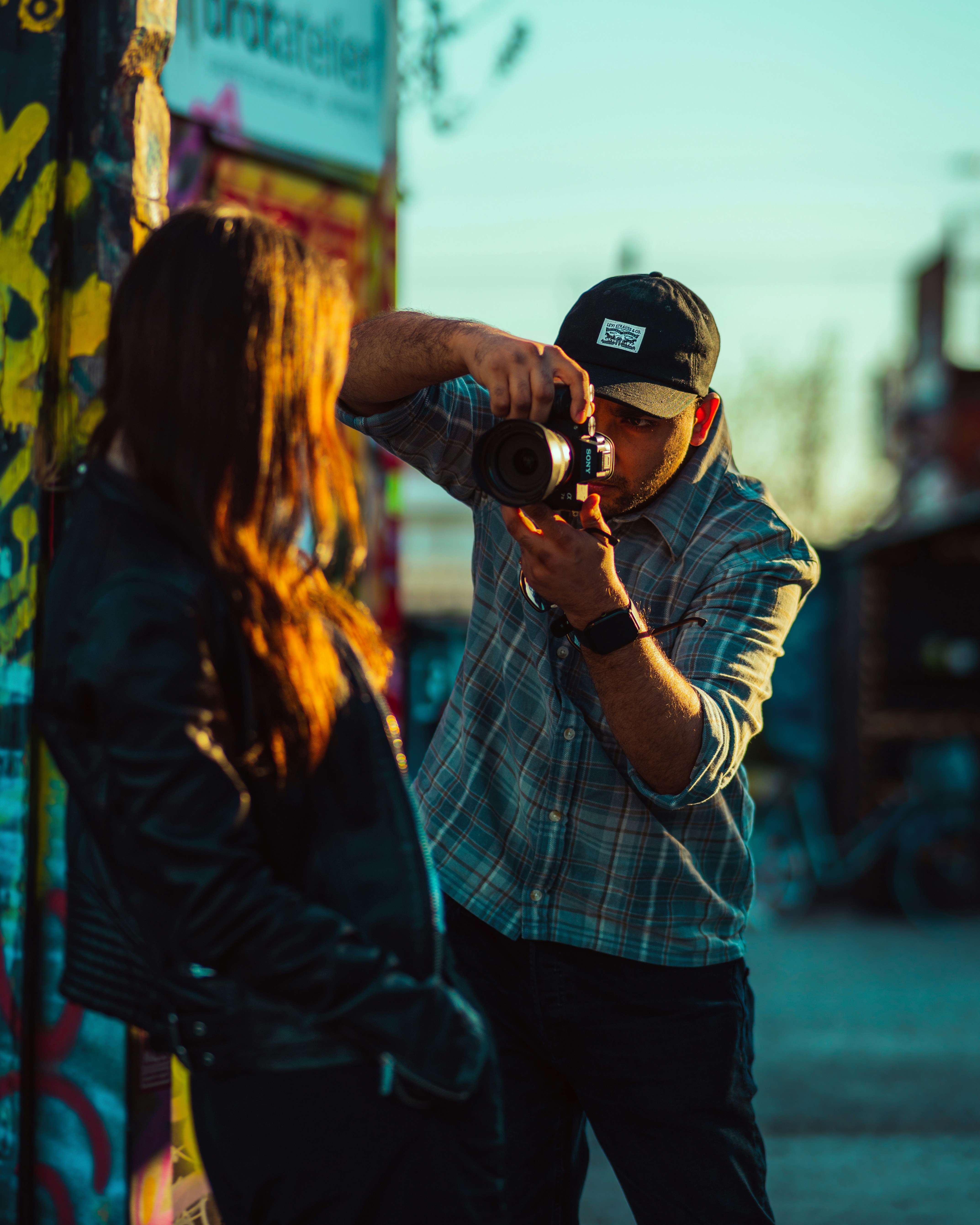 Fotografo che fotografa una donna vicino a un muro di graffiti