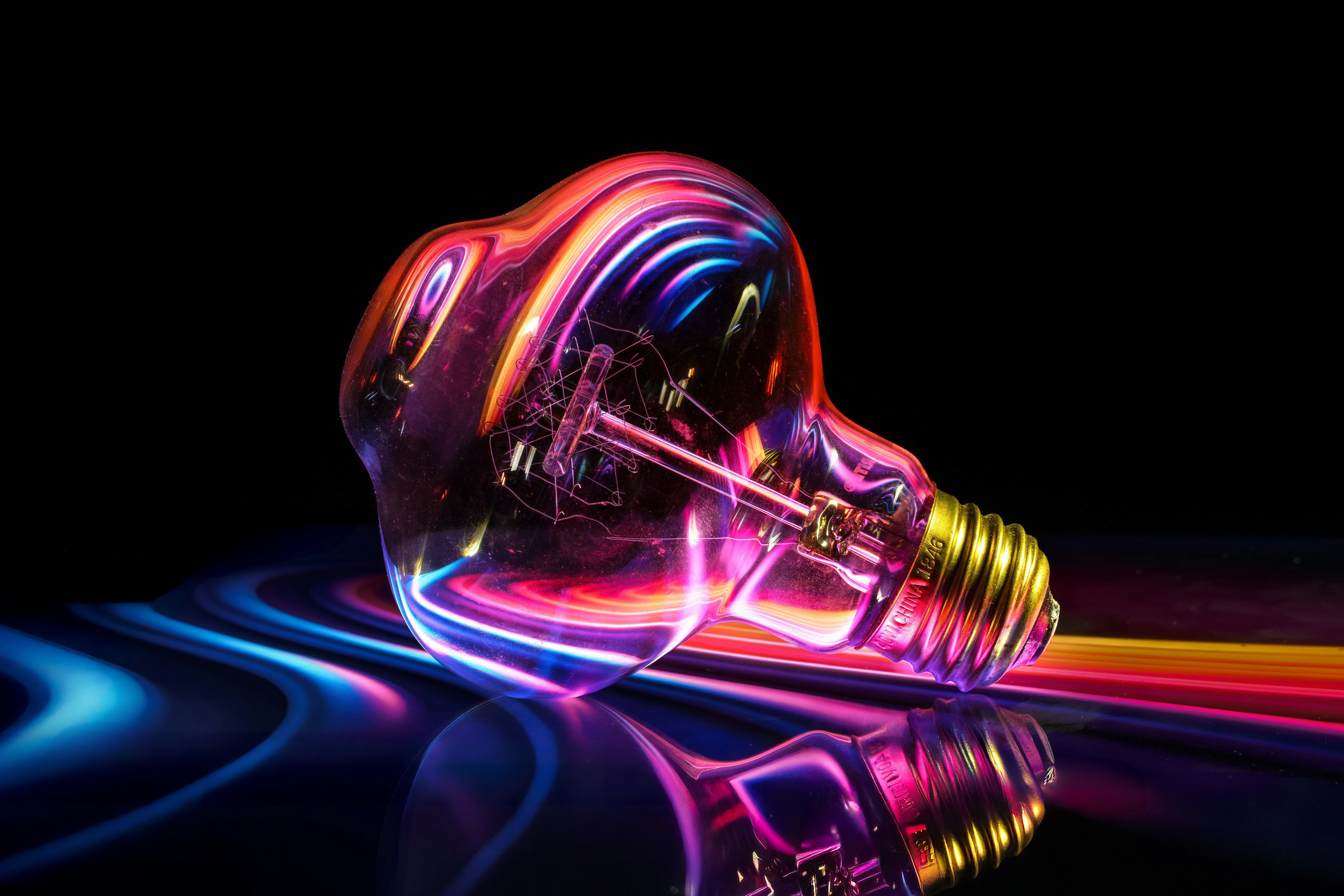 Une ampoule lumineuse aux reflets colorés sur un fond sombre