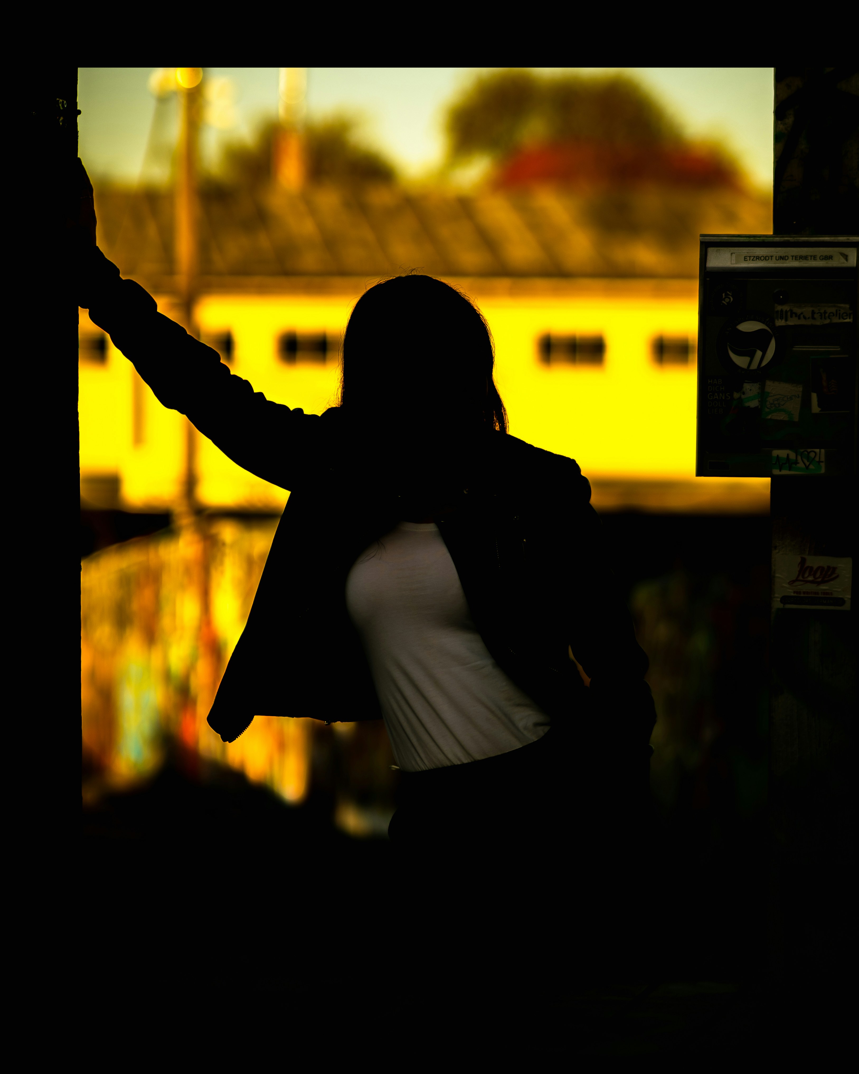 Silhouette of a woman against a yellow background.