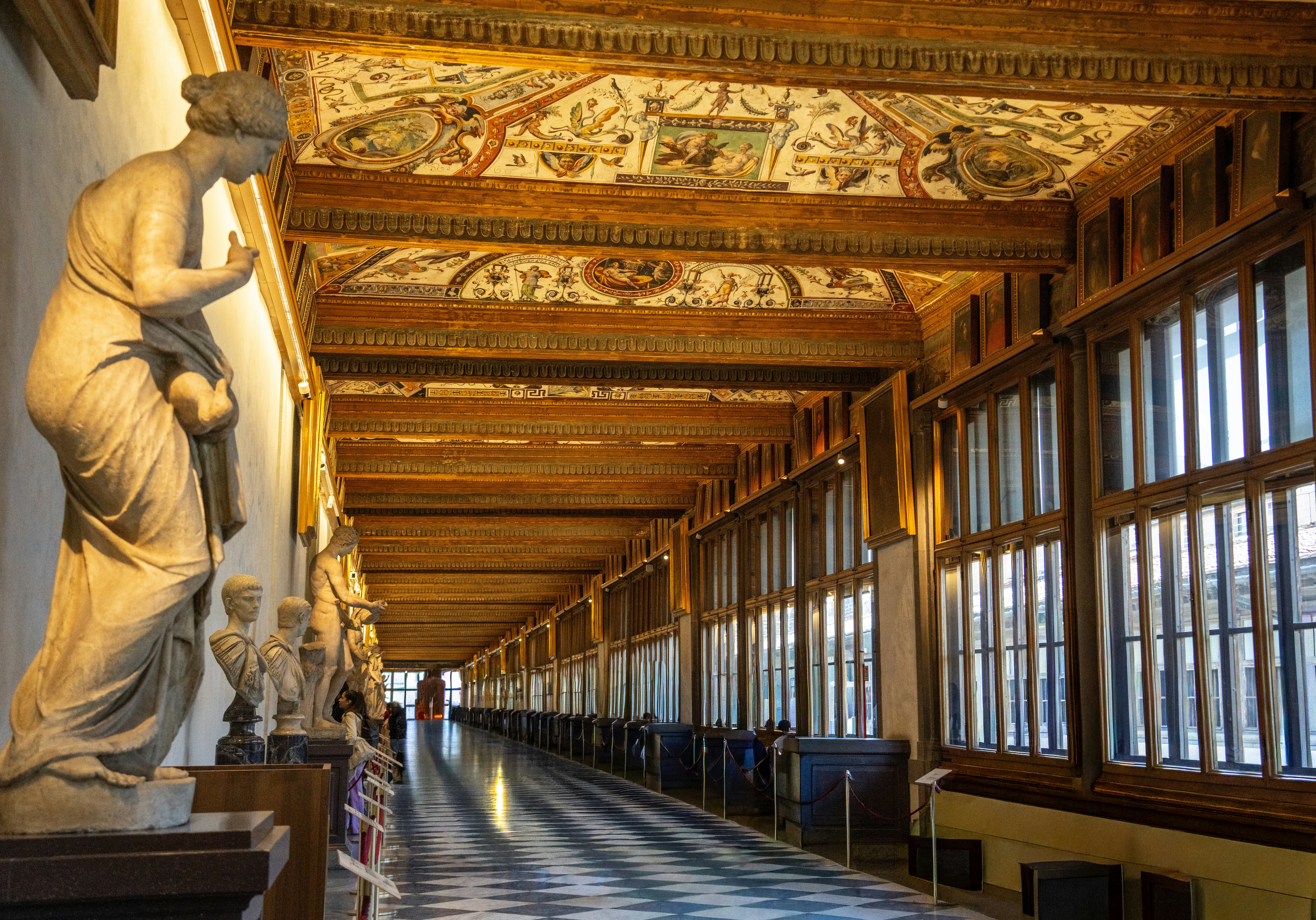 Long hallway with statues and ornate ceiling