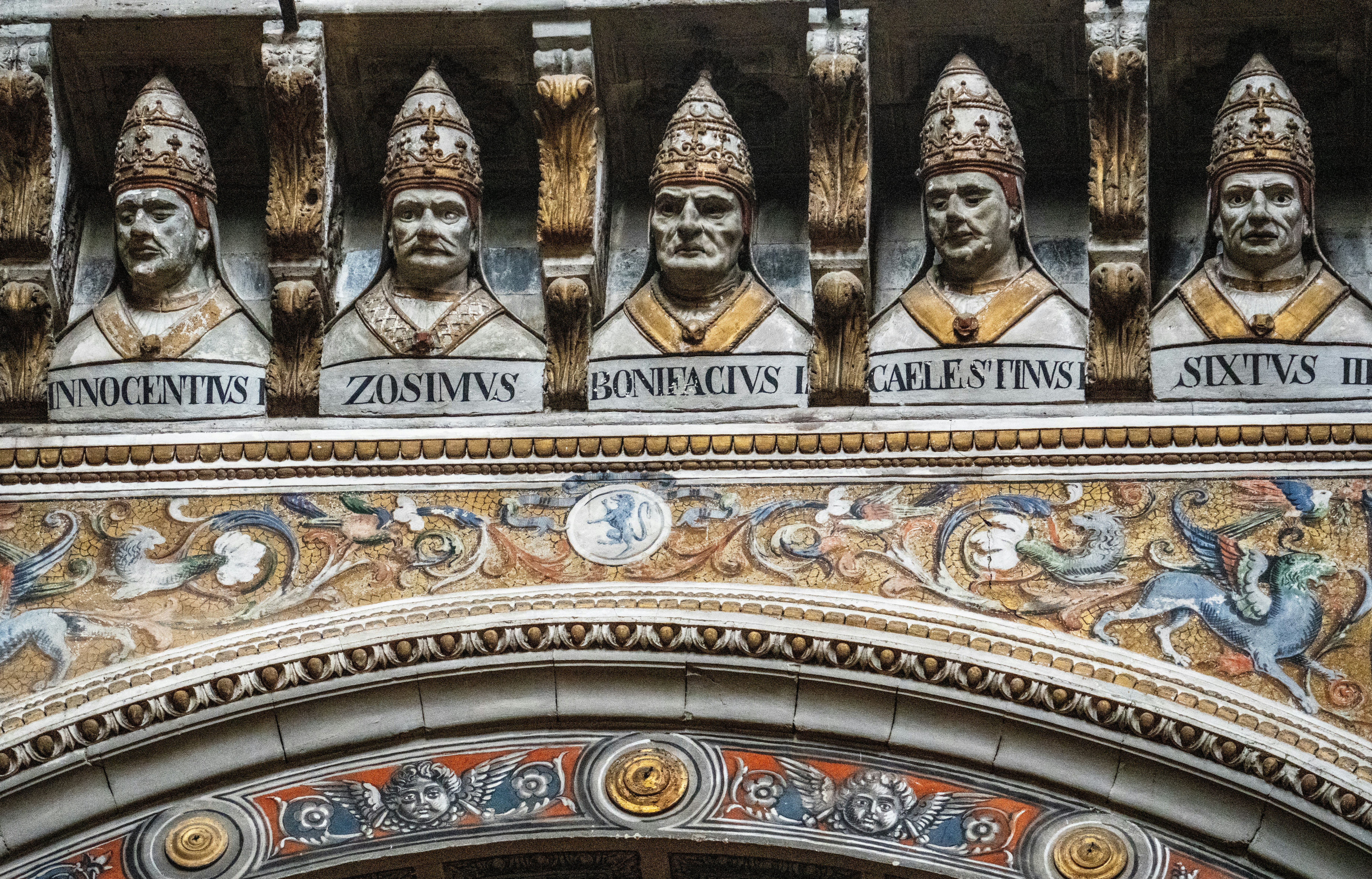 Five papal busts adorn ornate building facade