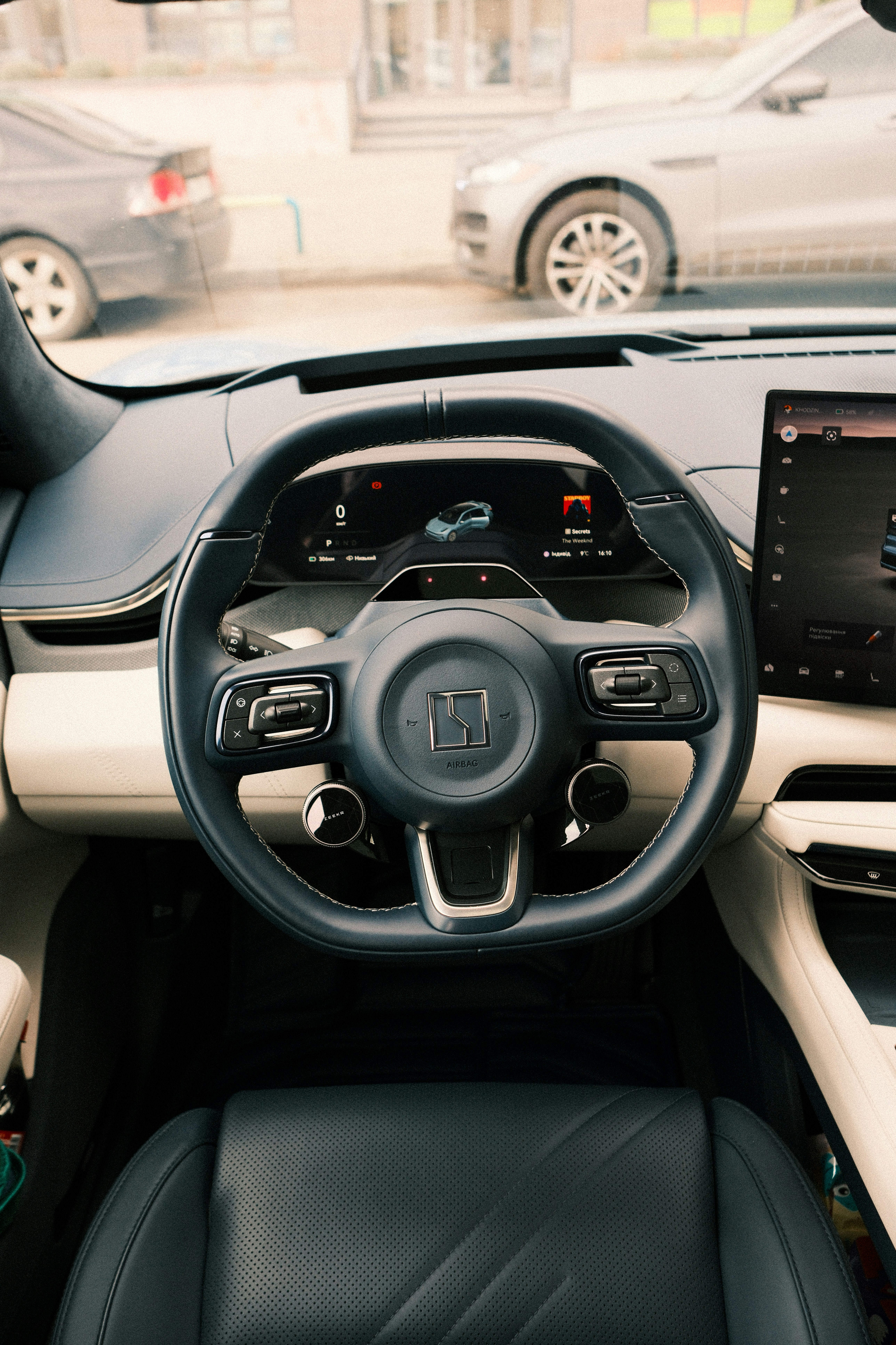 Modern car interior with steering wheel and dashboard.
