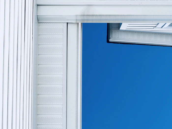 White house siding against a bright blue sky