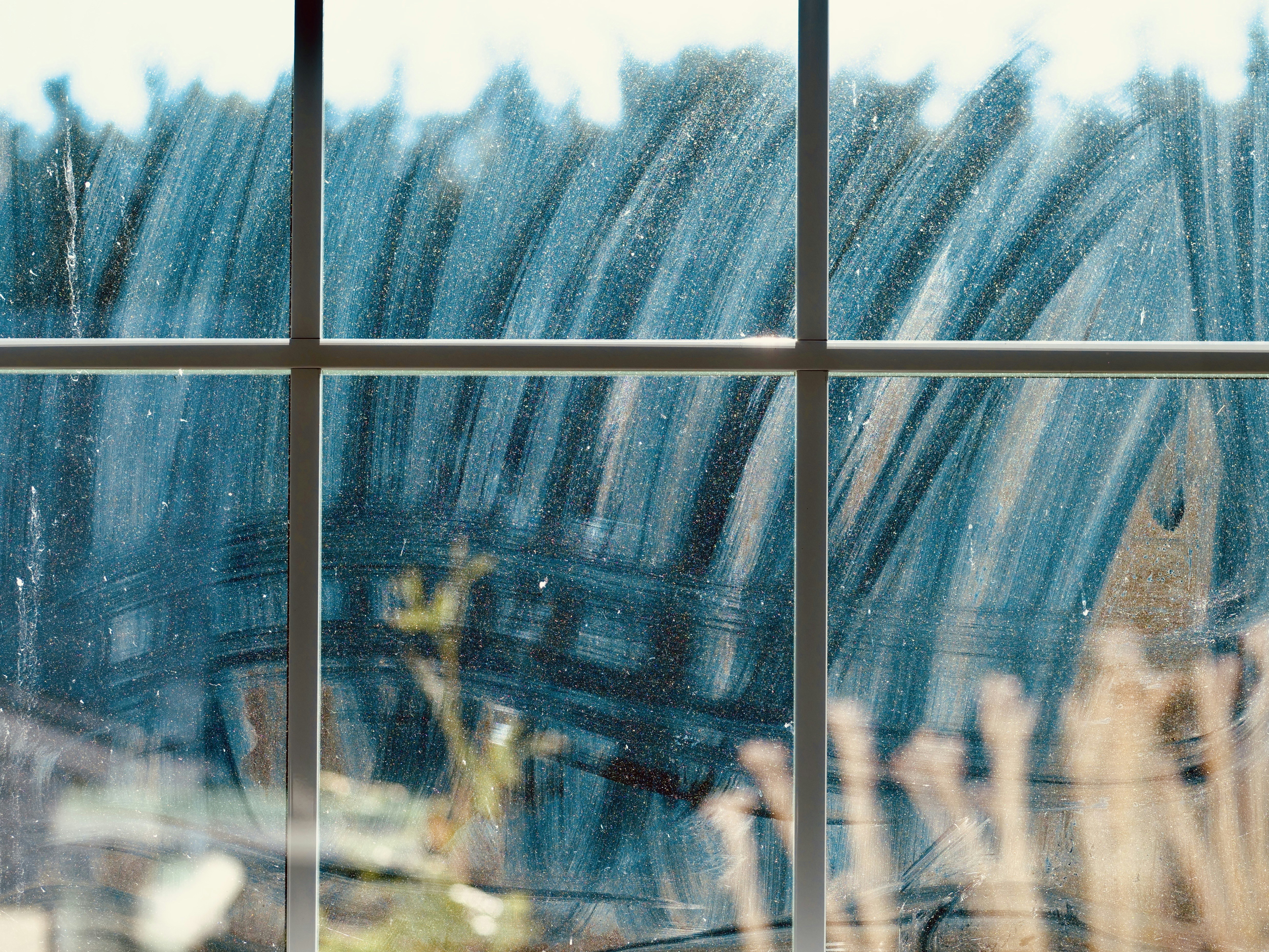 窓ガラスに描かれた抽象的な青と白の筋。