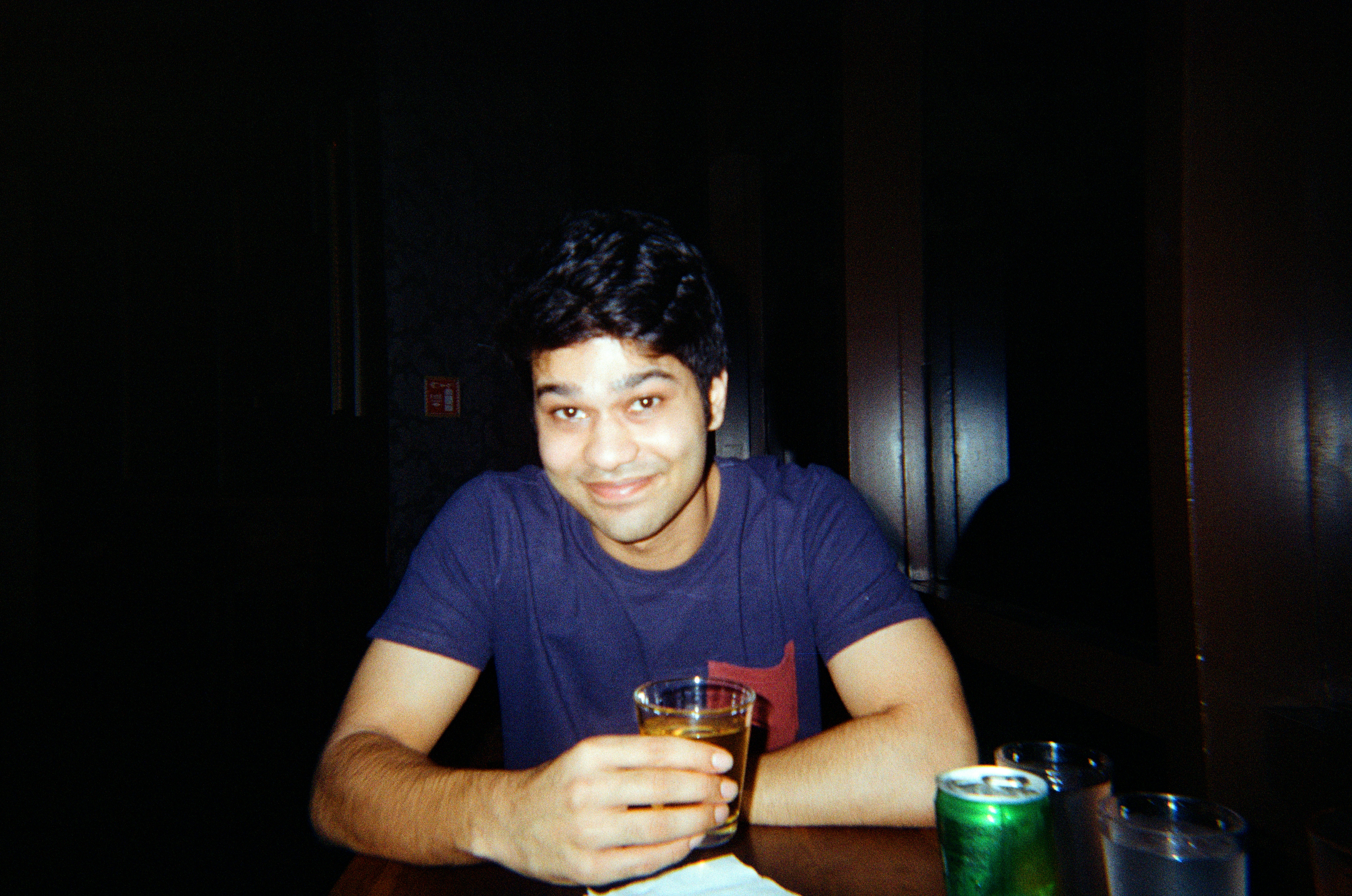 A man holding a drink at a bar