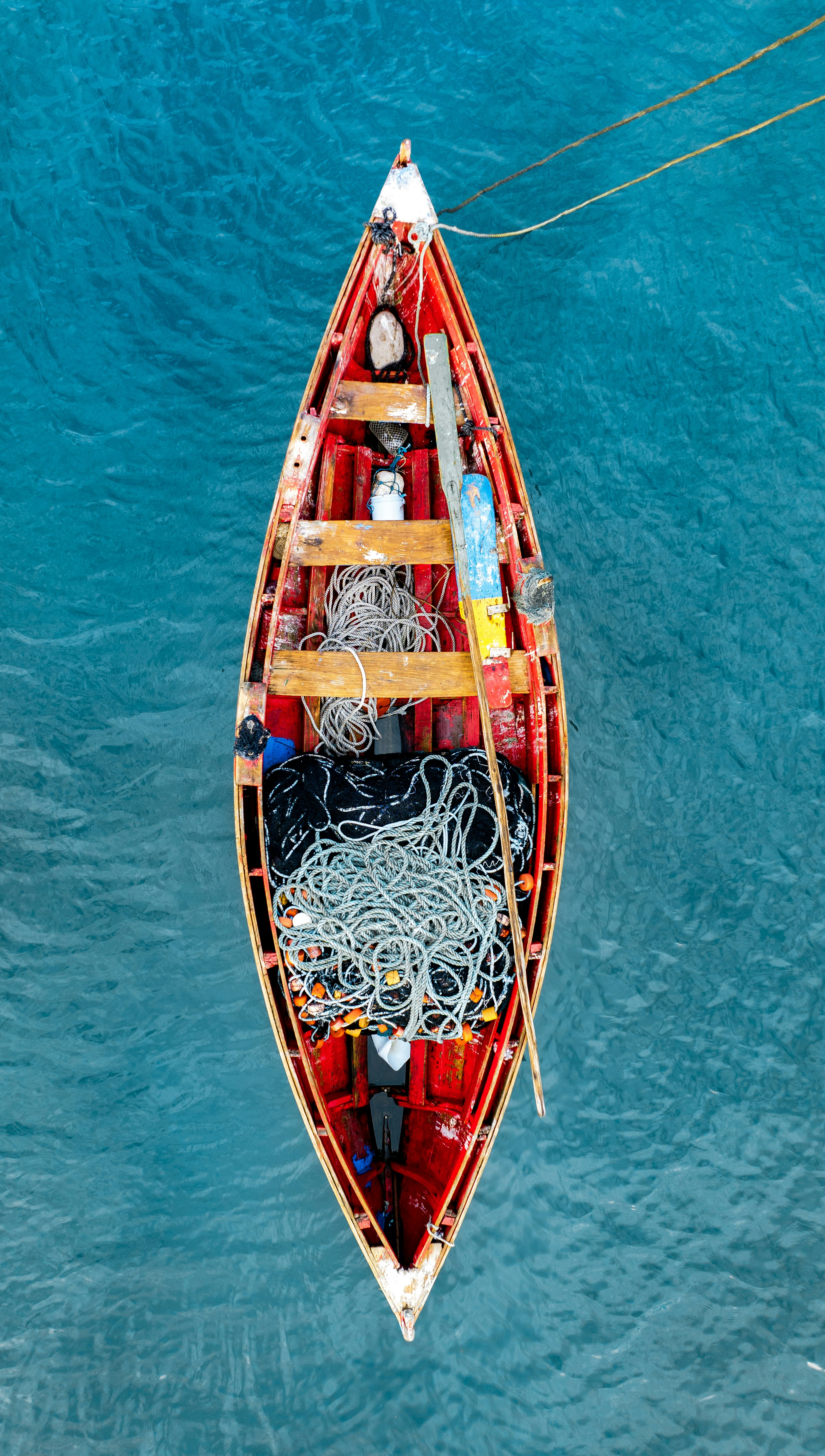 Bateau en bois rouge rempli de cordes sur l’eau bleue