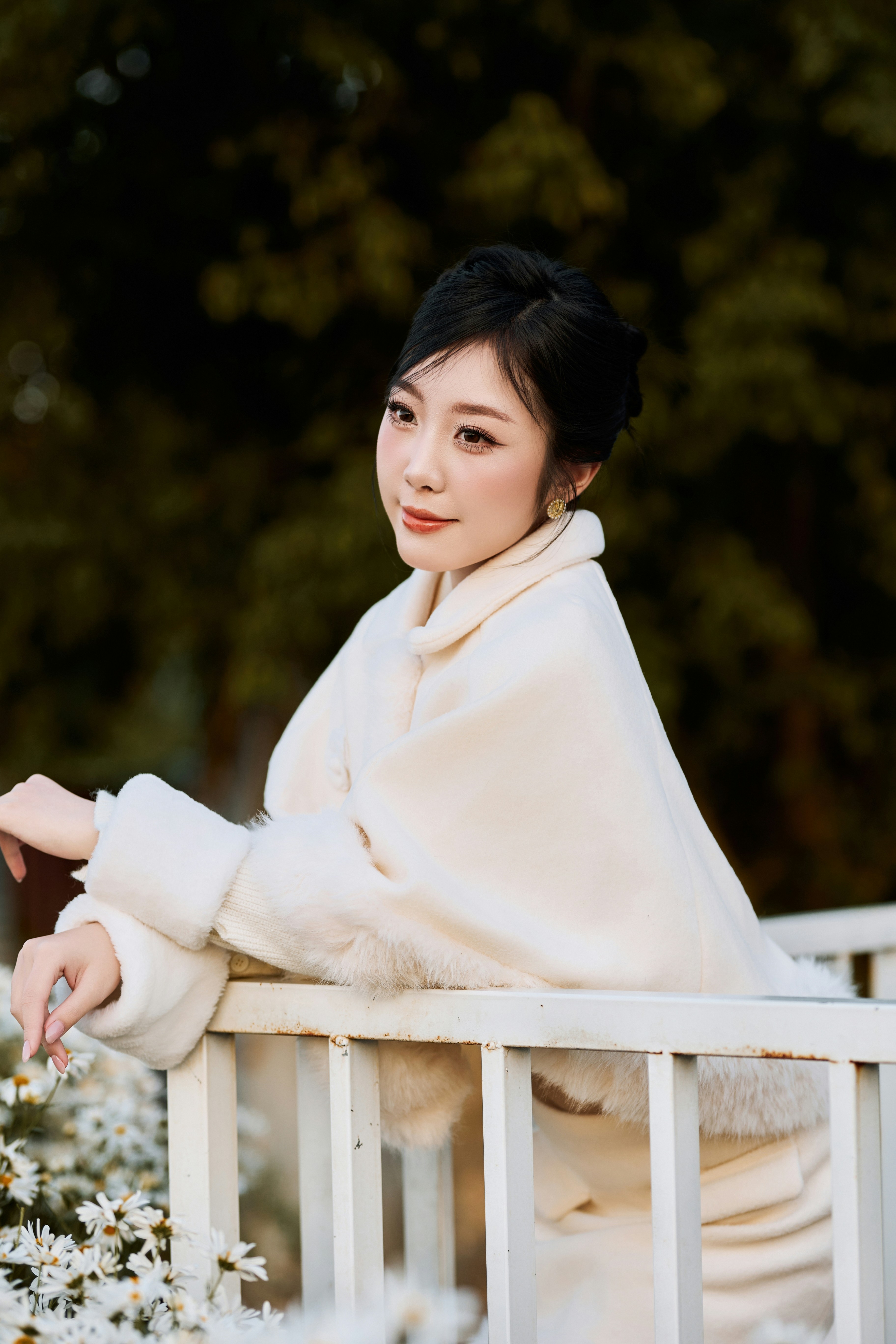 A woman in a white coat leaning on a railing