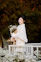 Woman in white coat holding bouquet of white flowers