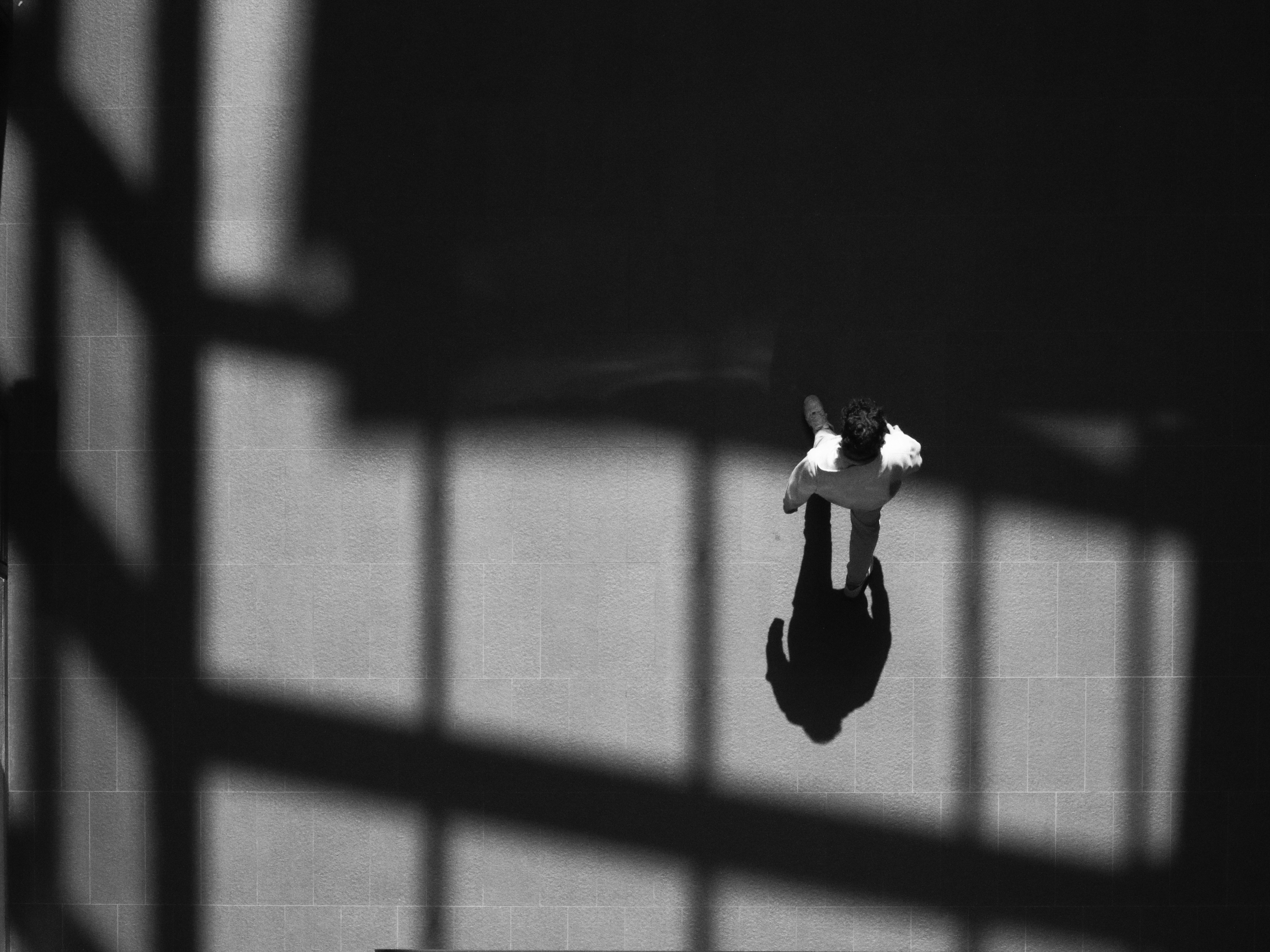 A person walks across a floor with shadows.