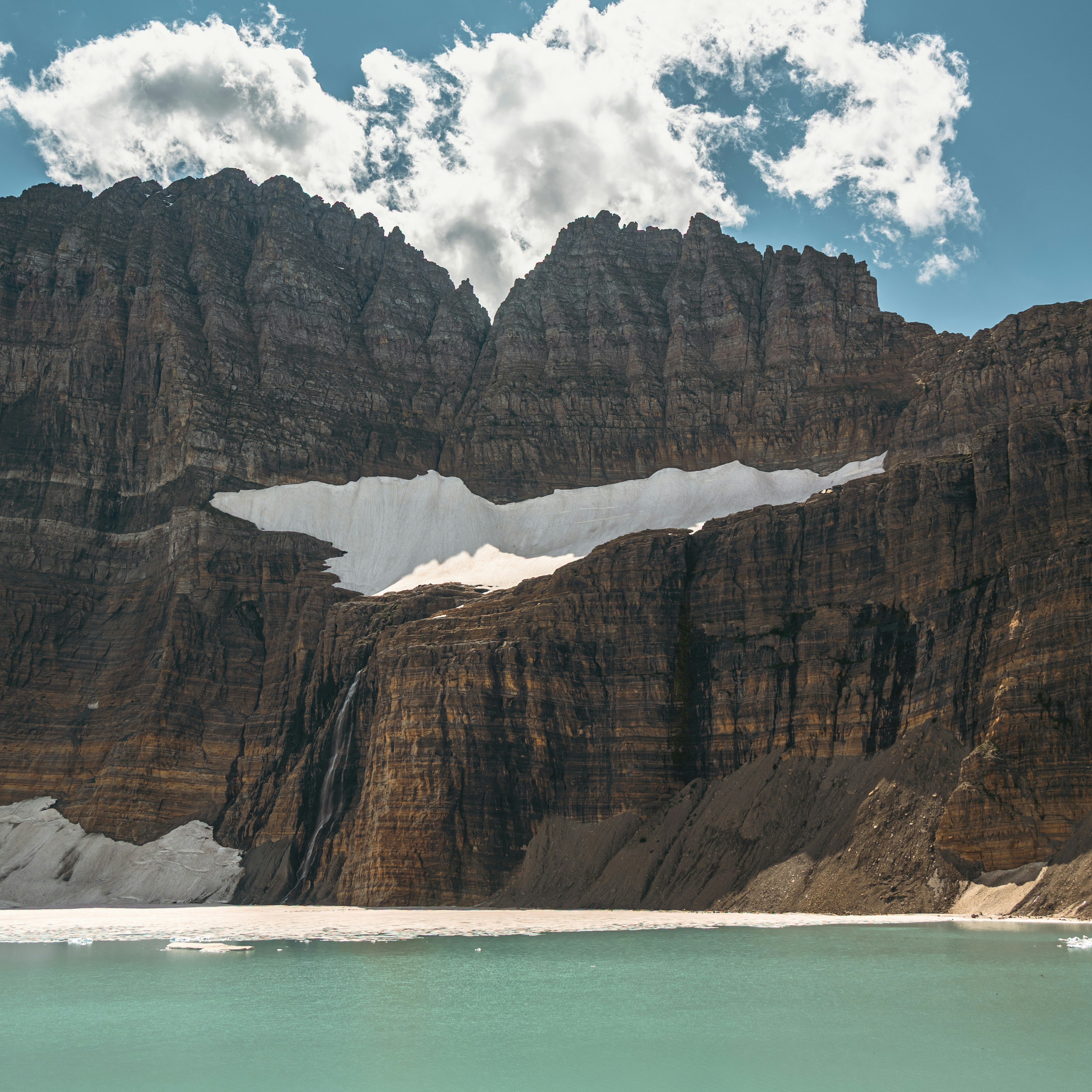 Majestic rocky mountains with snow patches and lake