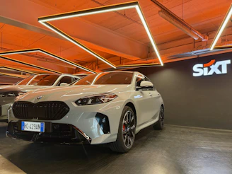 White BMW parked indoors with sixt logo