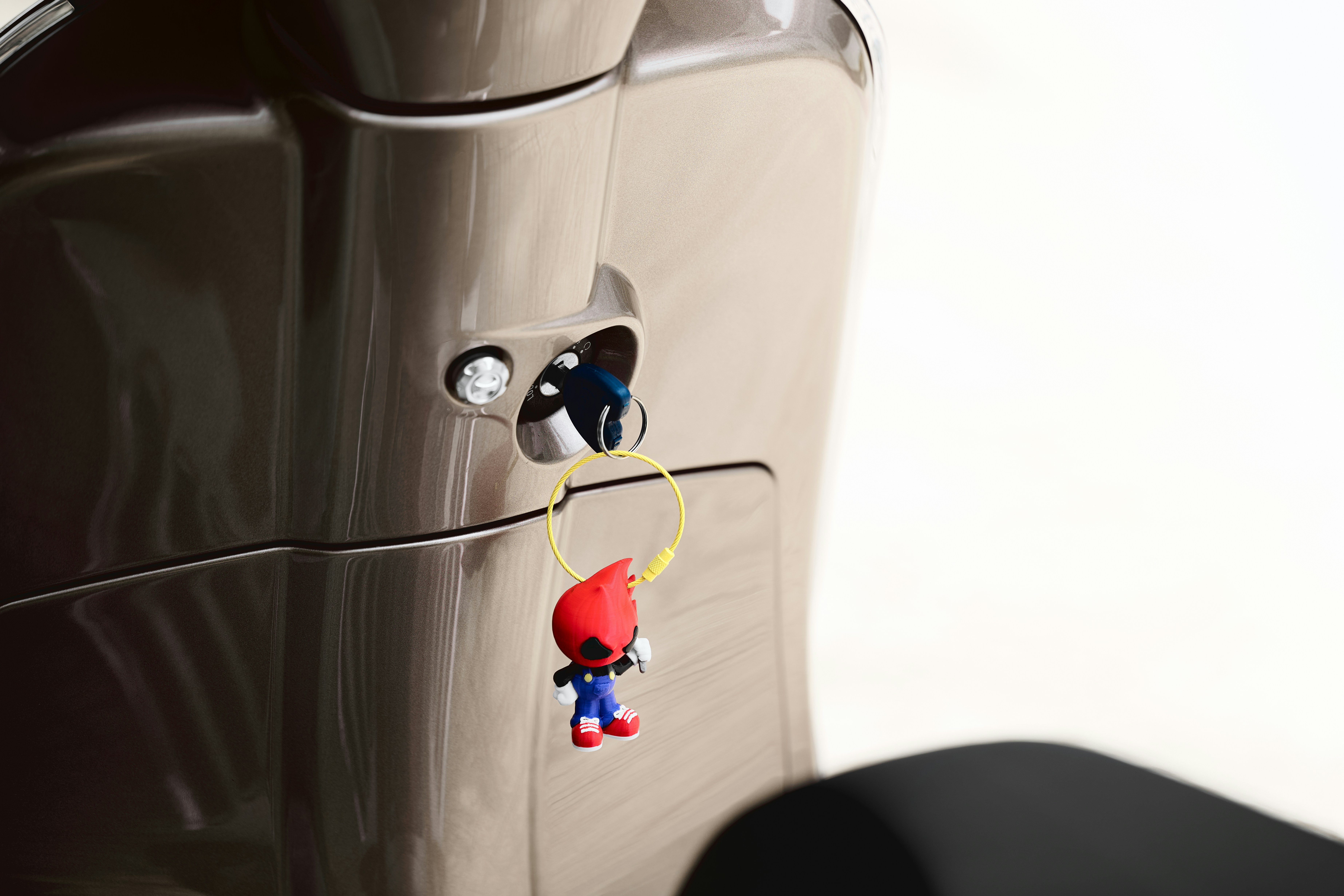 Eine kleine Mario-Figur hängt an einem Scooter-Zündschloss.