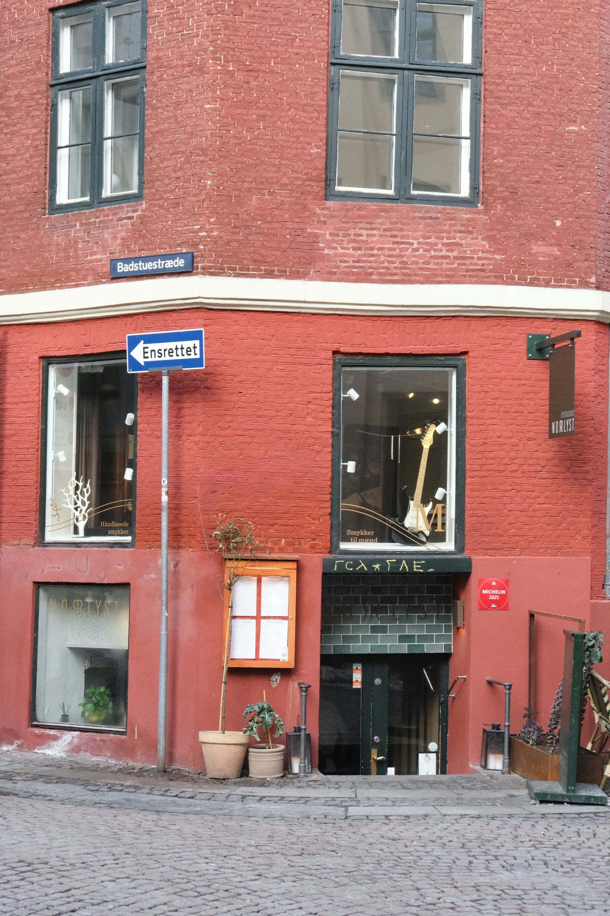 Rotes Backsteingebäude mit einer Gitarre im Fenster