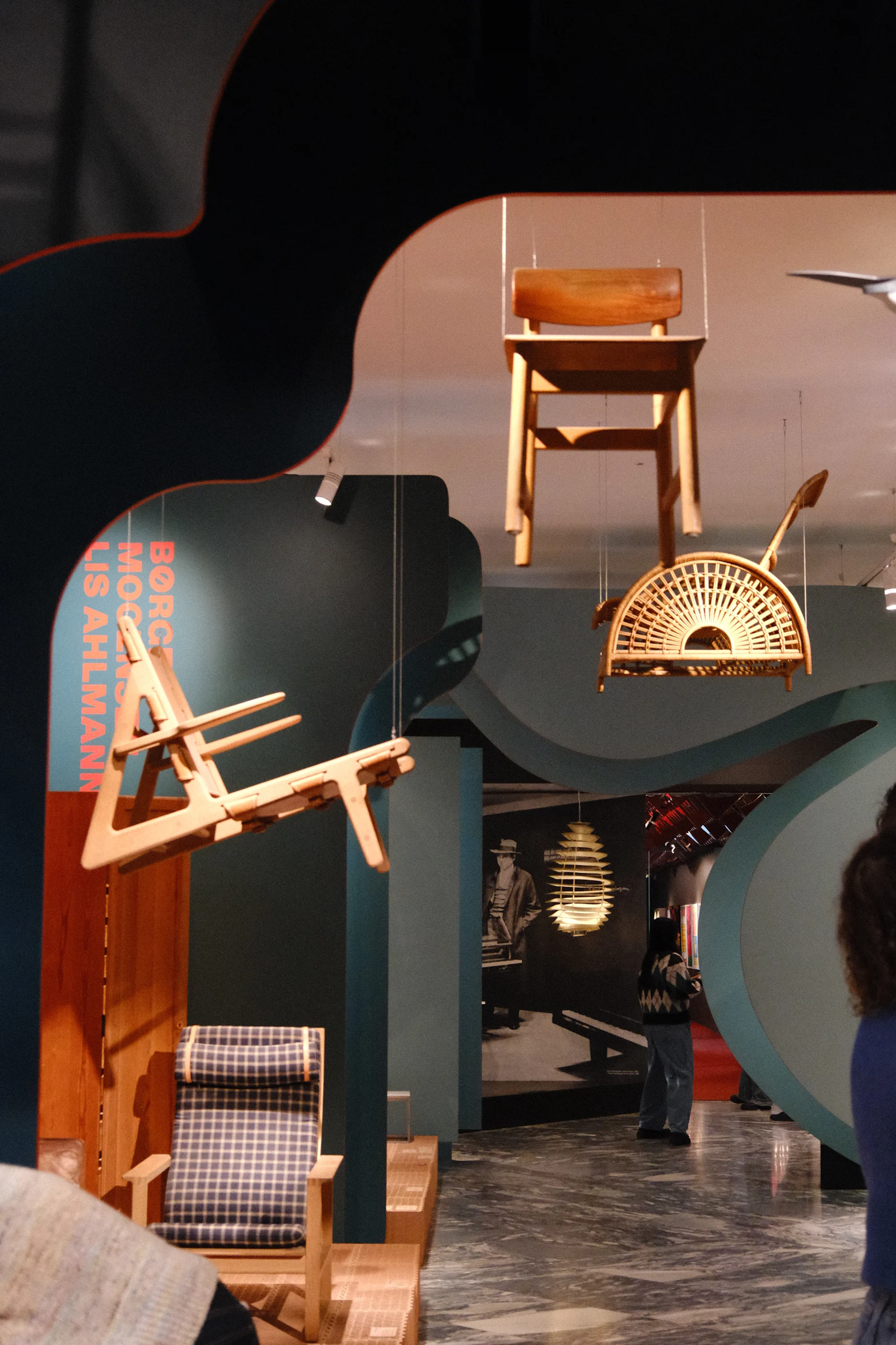 Wooden chairs standing on plinths in a museum display.