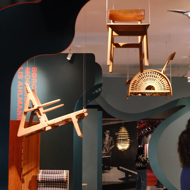 Wooden chairs displayed in a modern museum exhibition