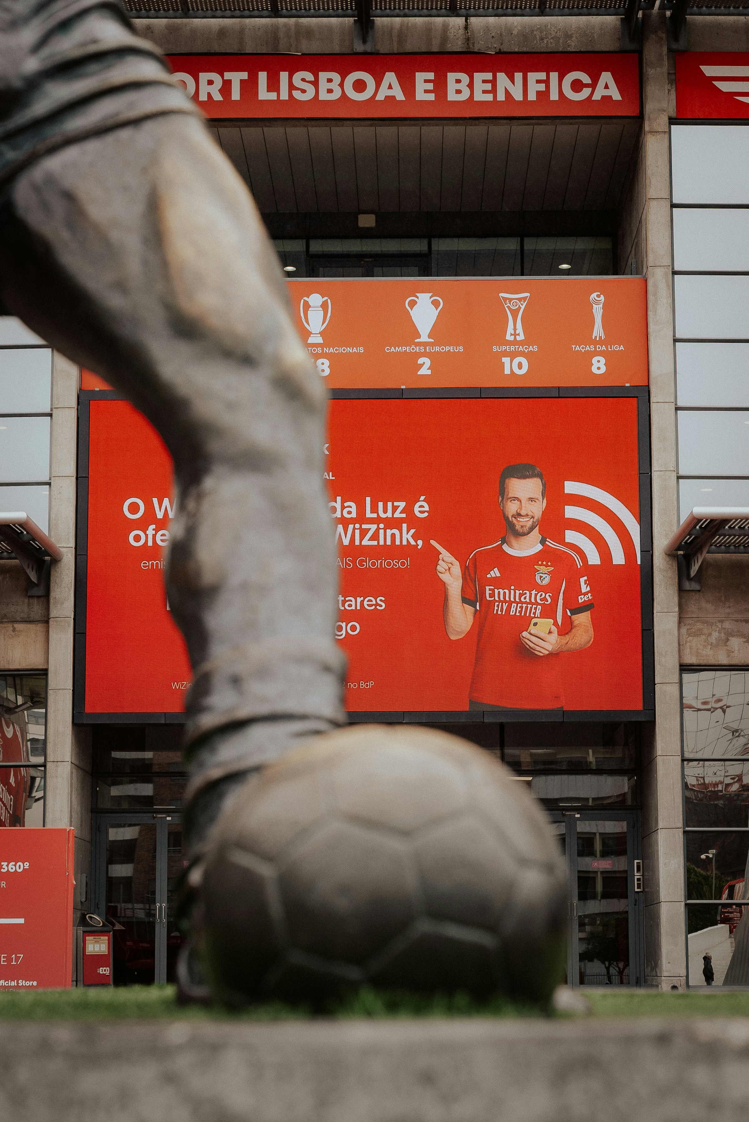 Statue of a soccer player in front of stadium