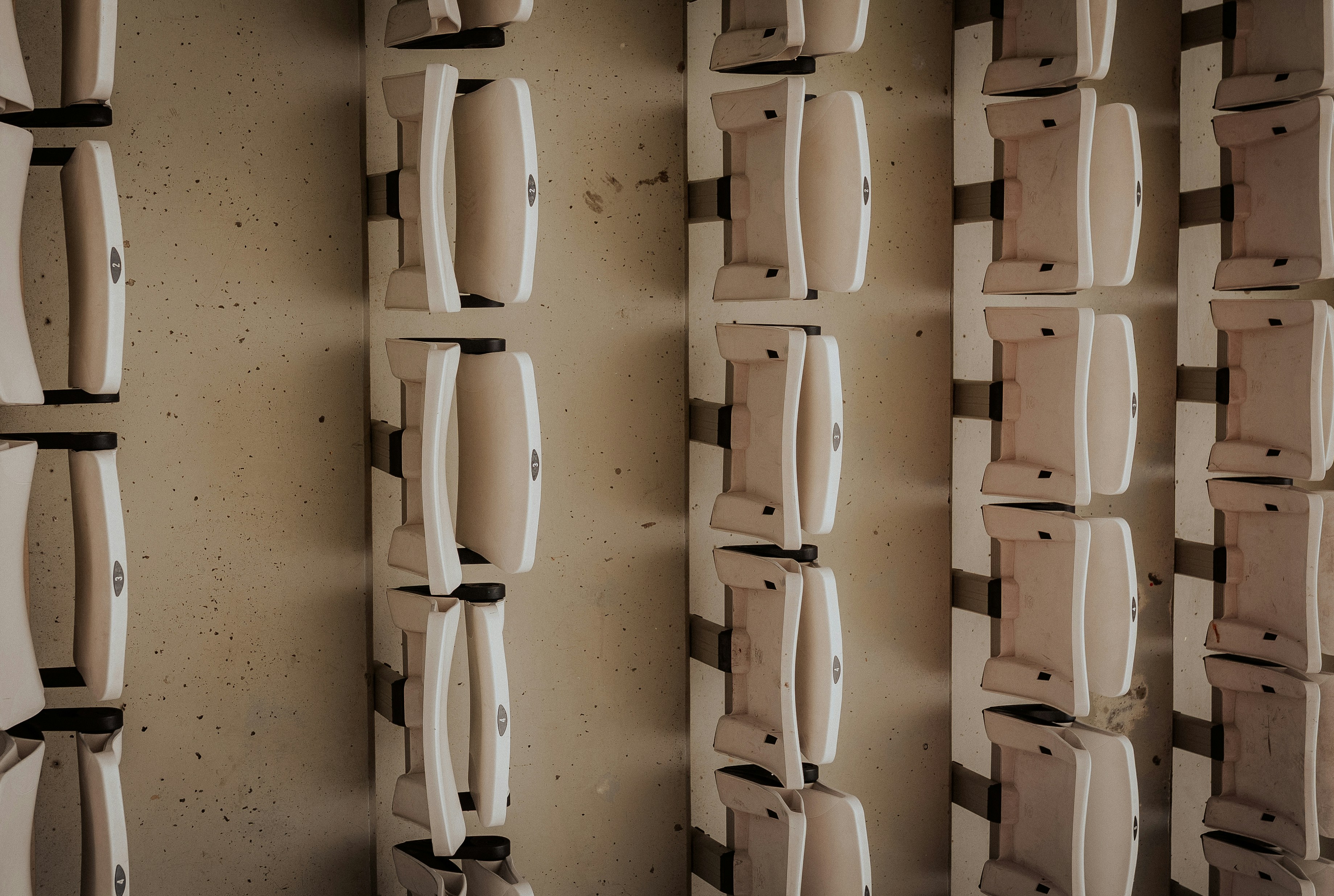 Des rangées de sièges blancs vides dans un stade.