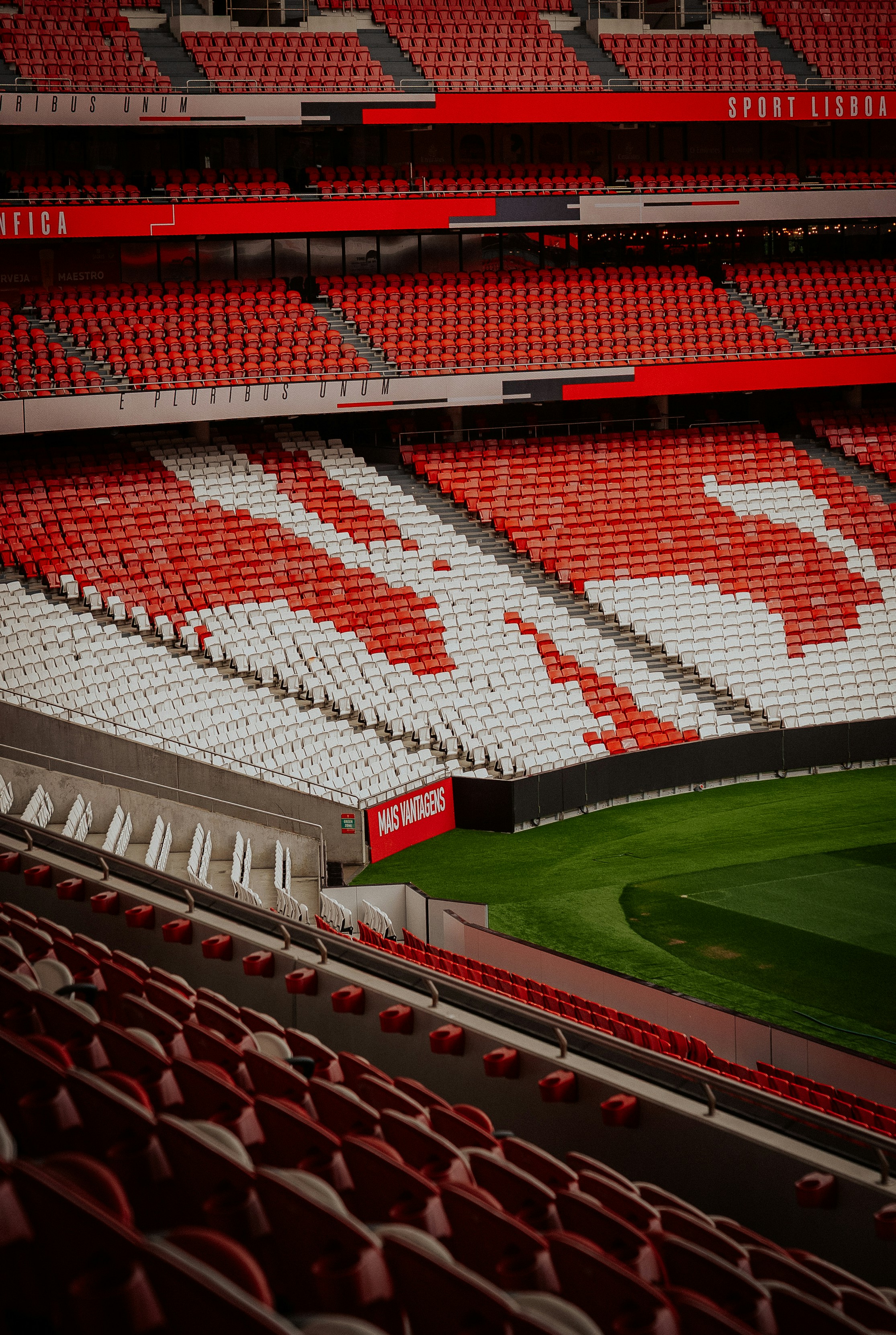 Des sièges vides de stade rouges et blancs vues d’en haut.