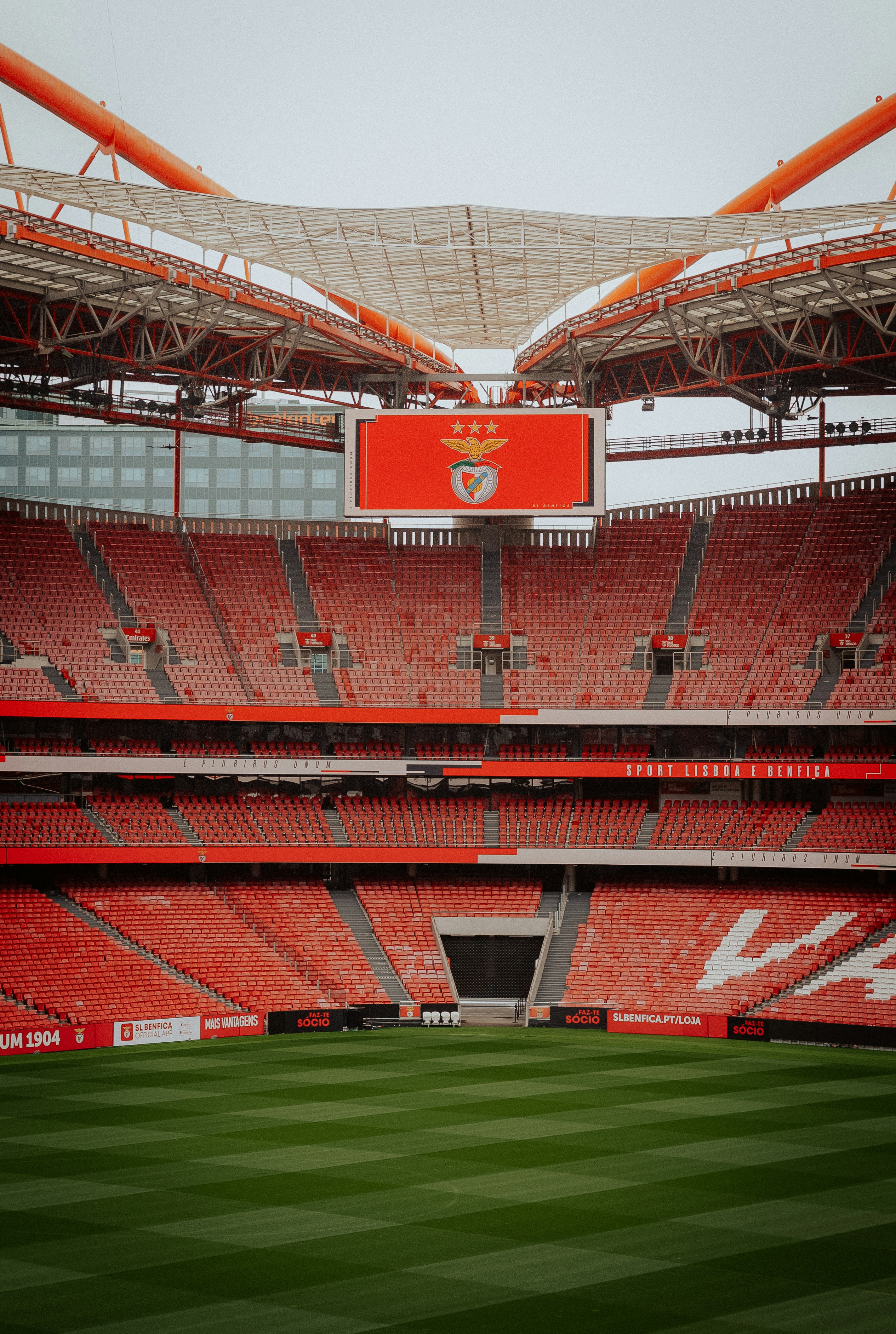 Stade vide avec sièges rouges et terrain vert