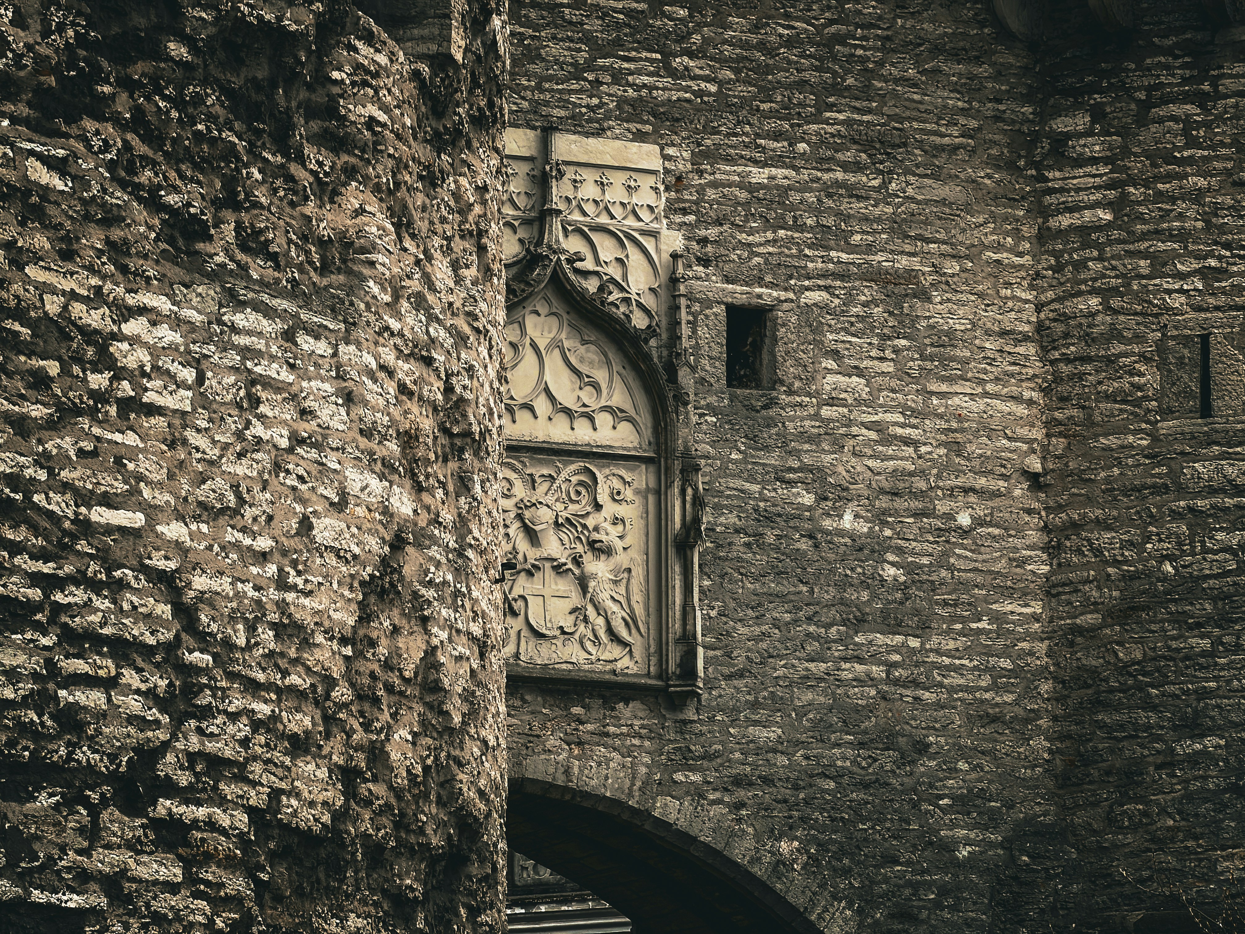 Ancient stone archway with intricate carvings and weathered texture