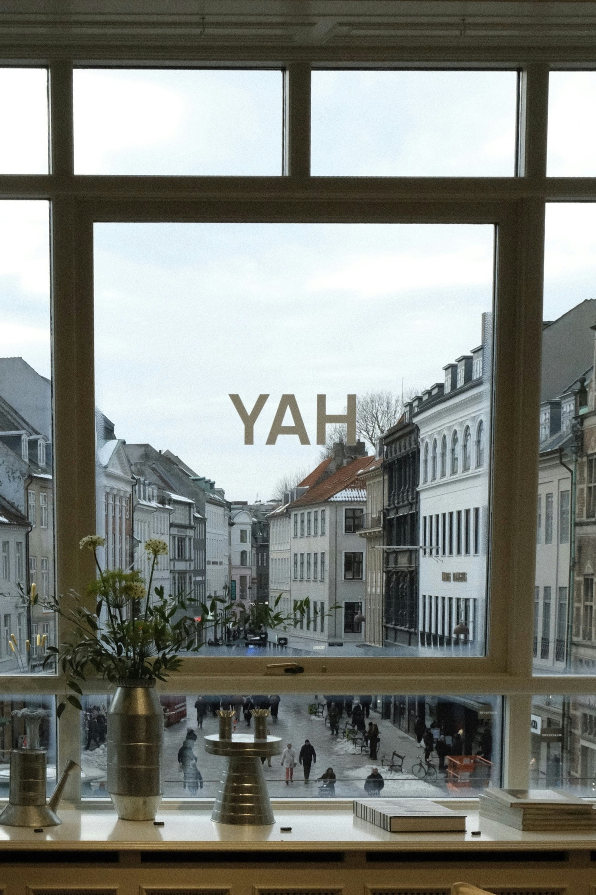 Blick auf eine Straße durch ein Fenster mit "yah"-Text.