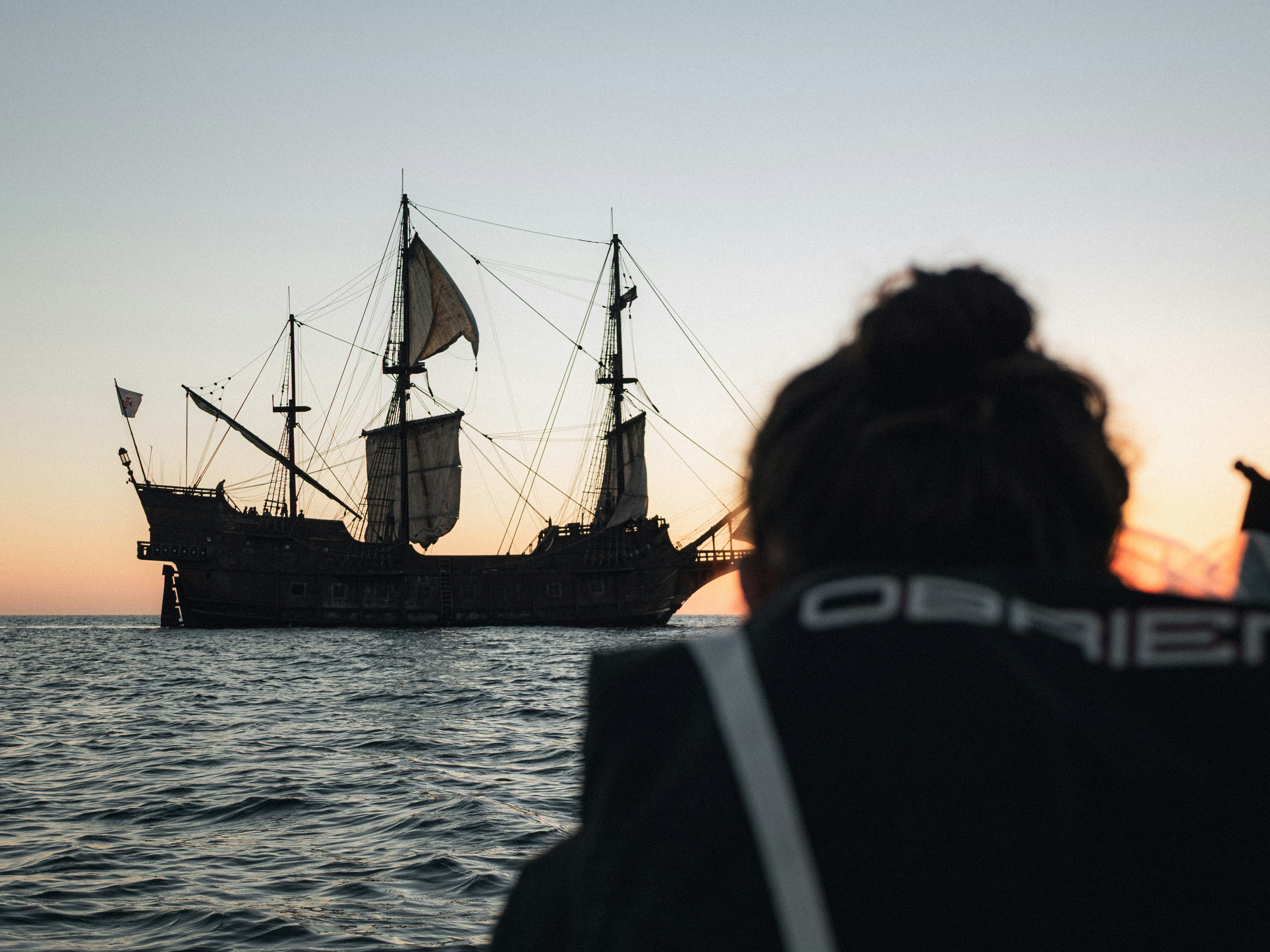 Silhouette of a historic sailing ship at sunset