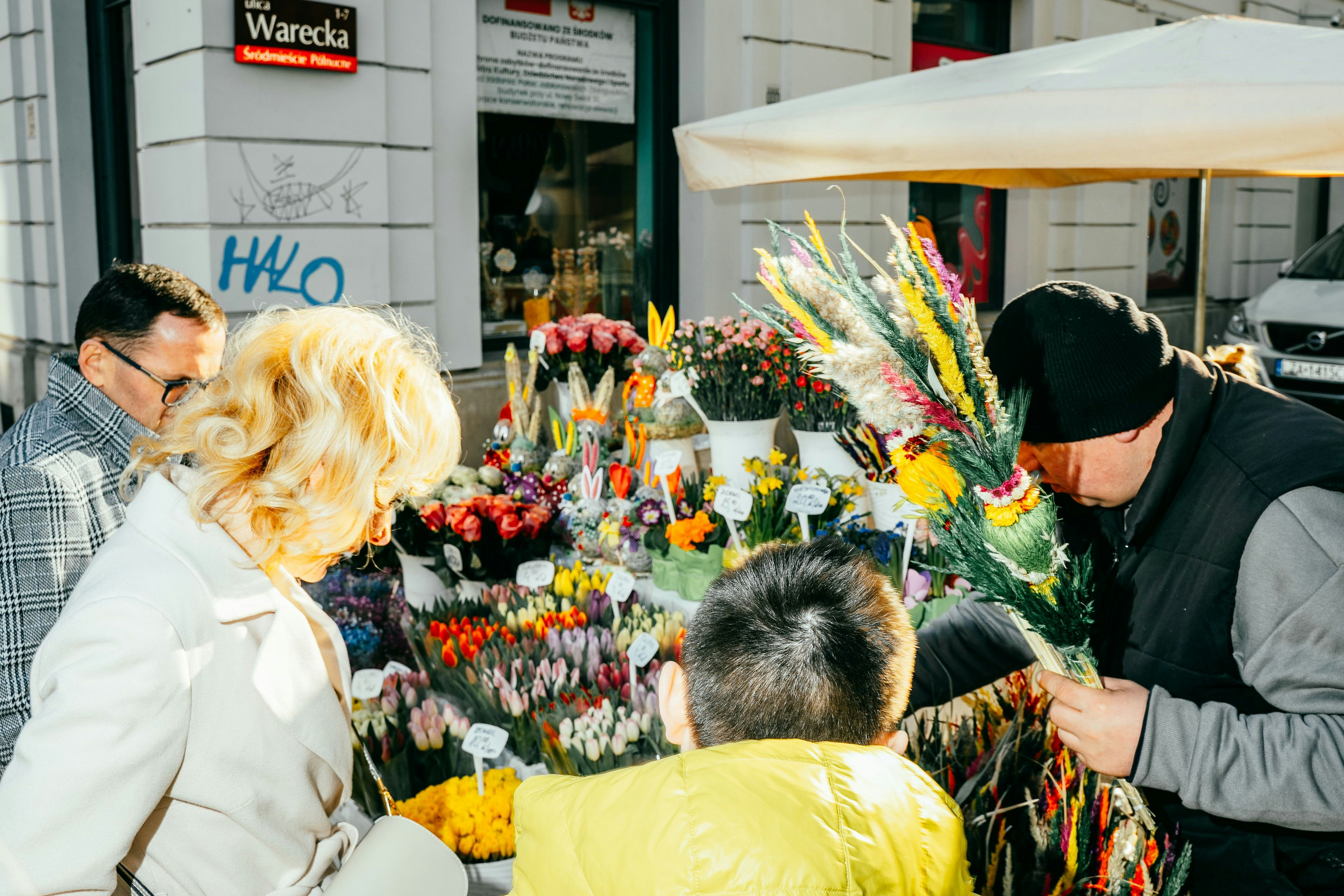 people browsing bouquets of flowers at an outdoor flower market