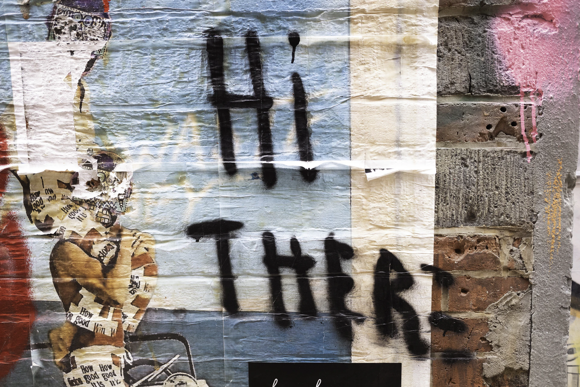 Graffiti text reads "hi there" on a brick wall.
