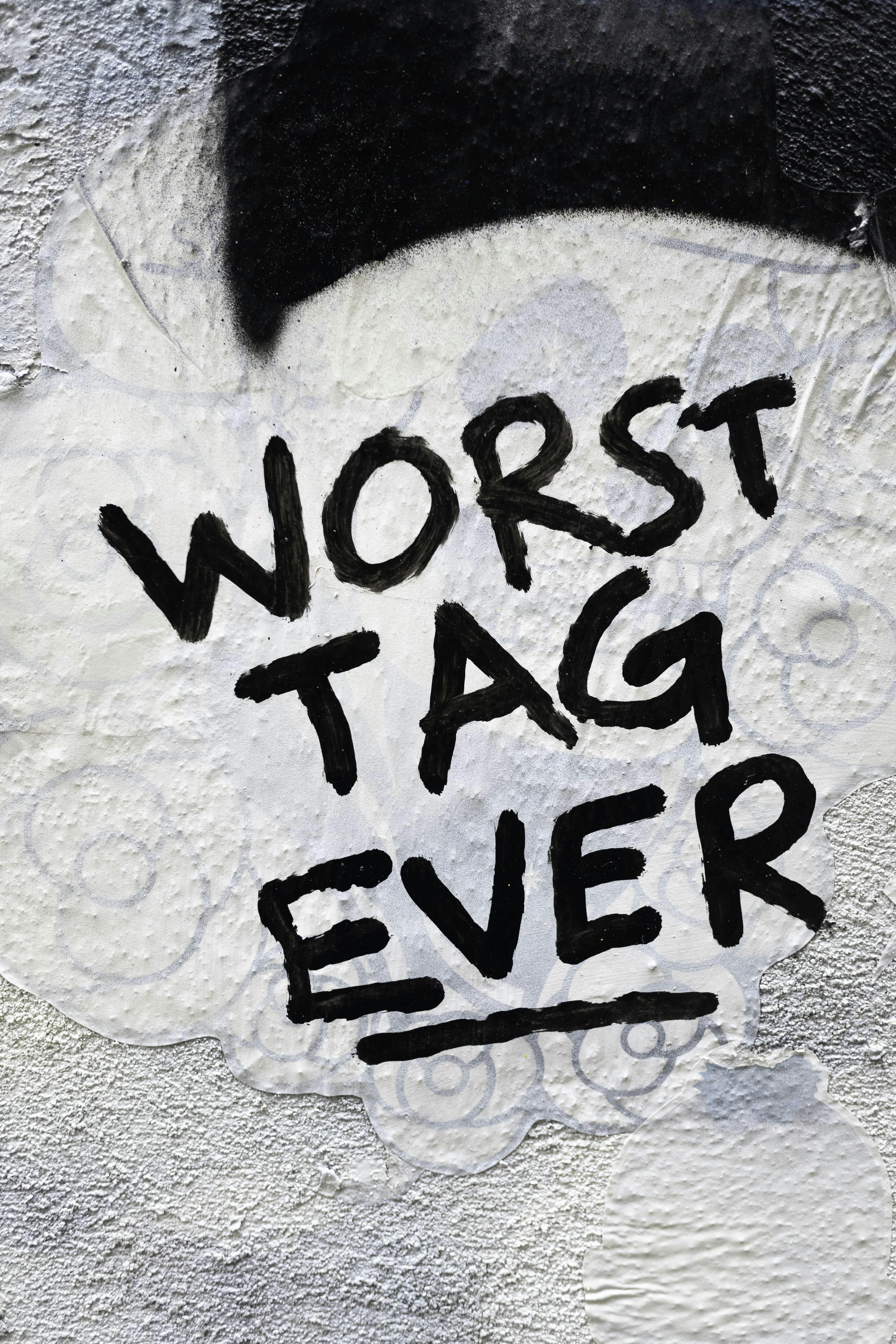 Graffiti on a wall reads "worst tag ever"