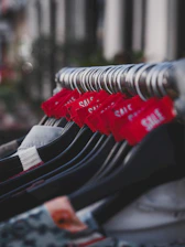 Red sale tags on clothing hangers