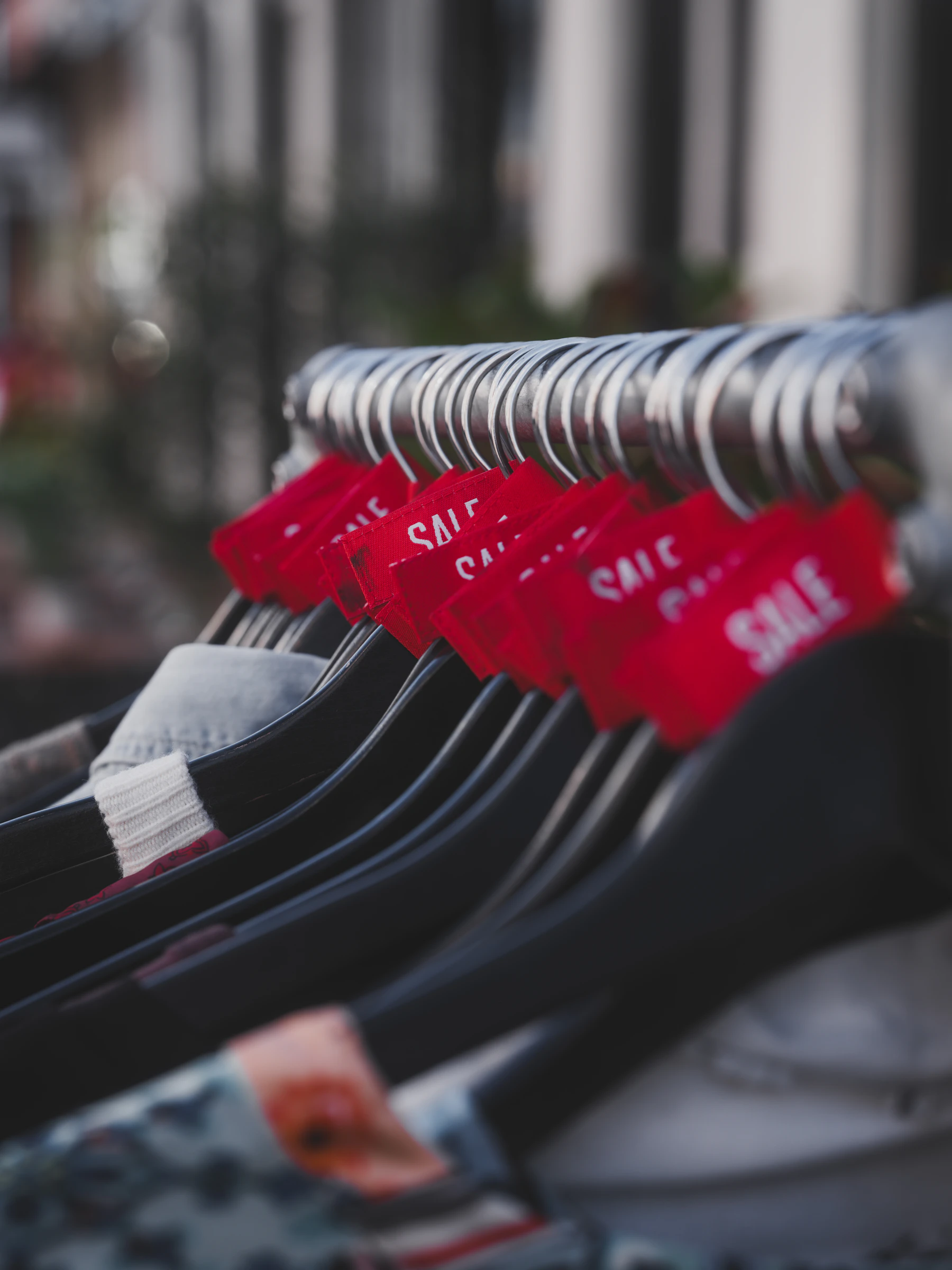 Red sale tags on clothing hangers