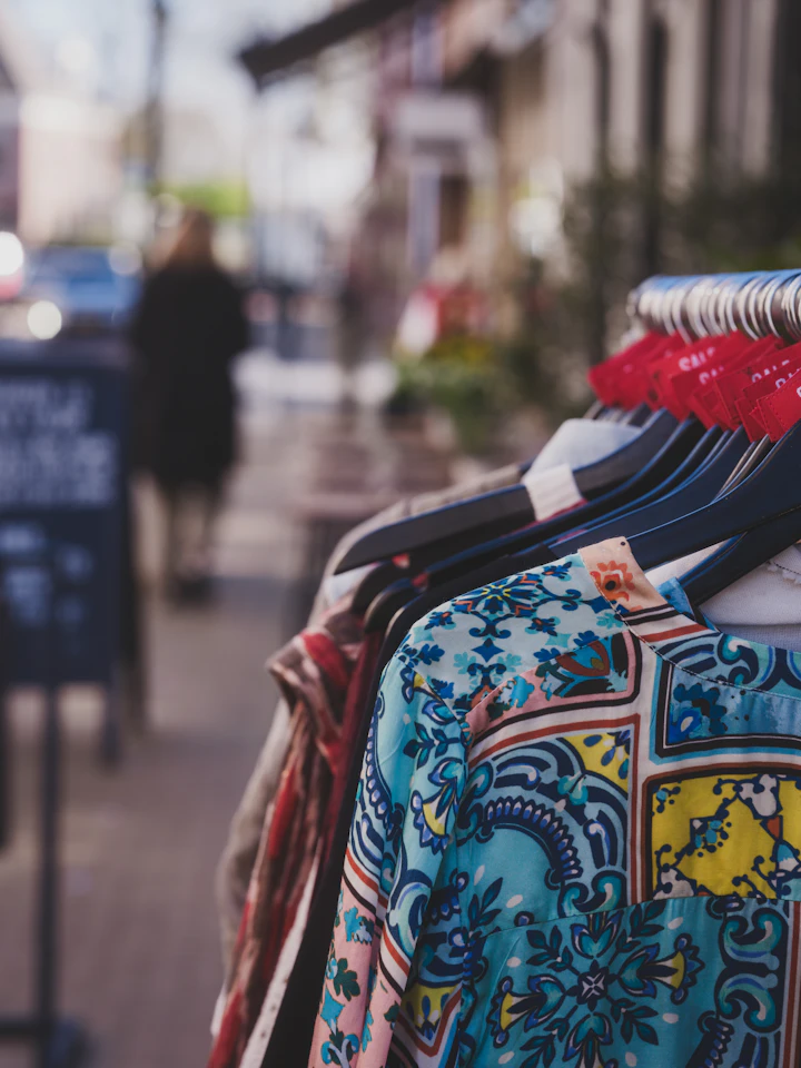 Colorful patterned clothes hanging on a rack outdoors