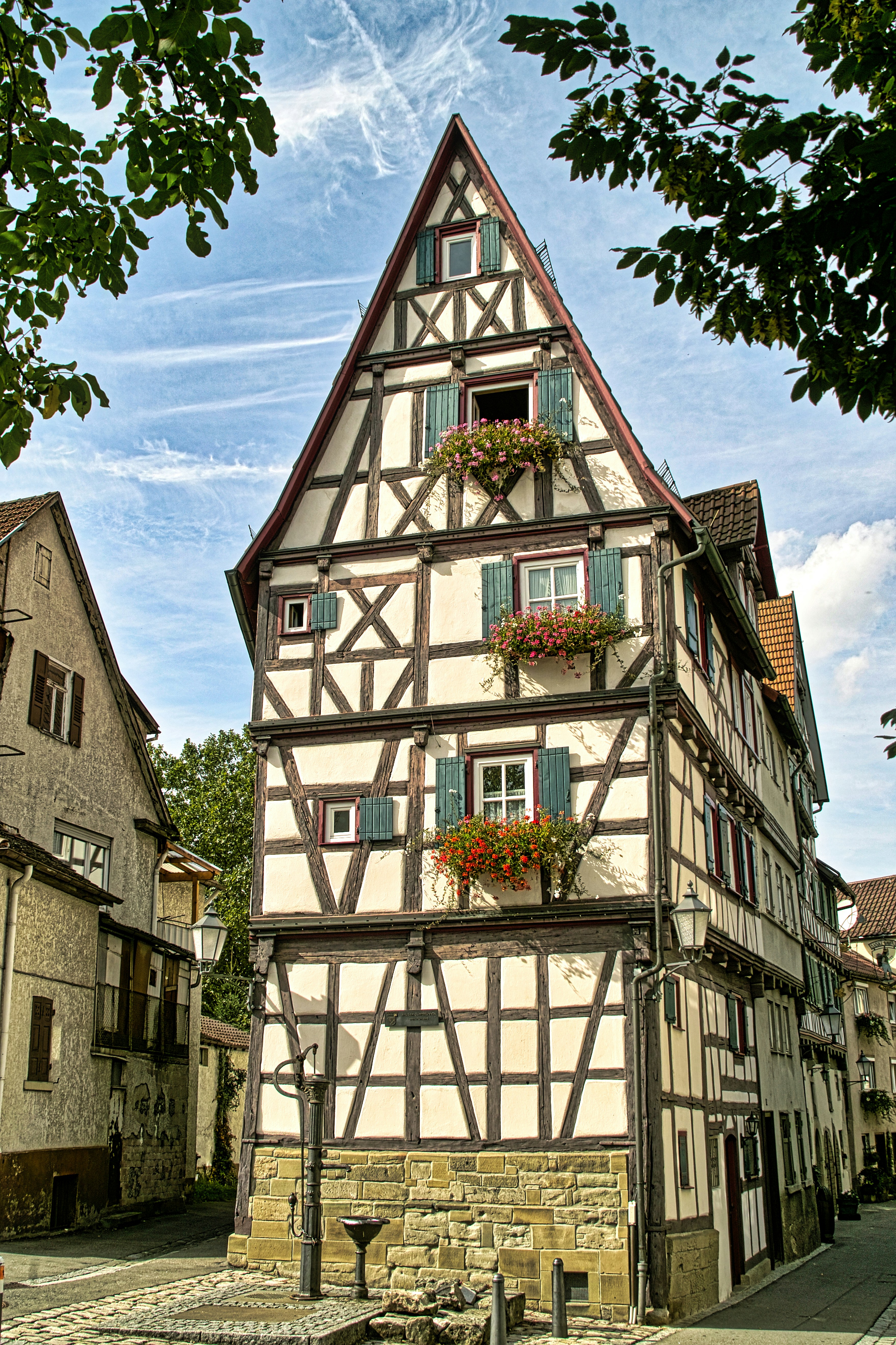 Historic half-timbered house with flowers on windowsills.